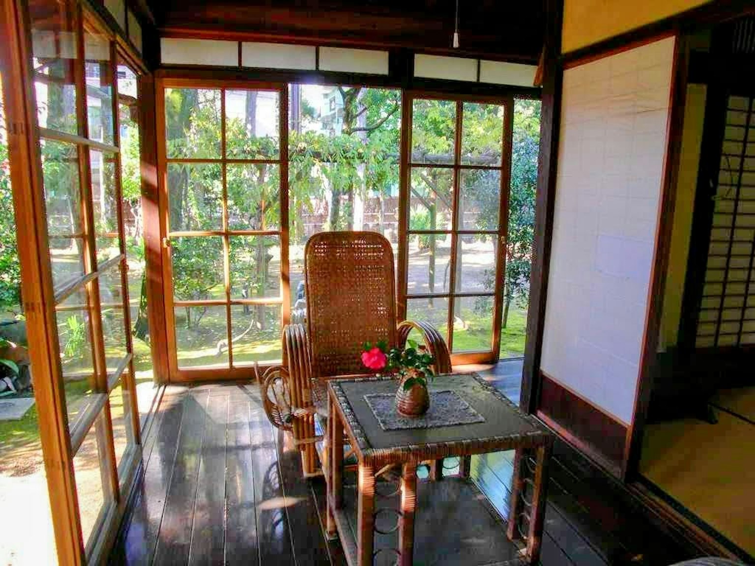 Japanese-style room with wooden chair and table overlooking greenery