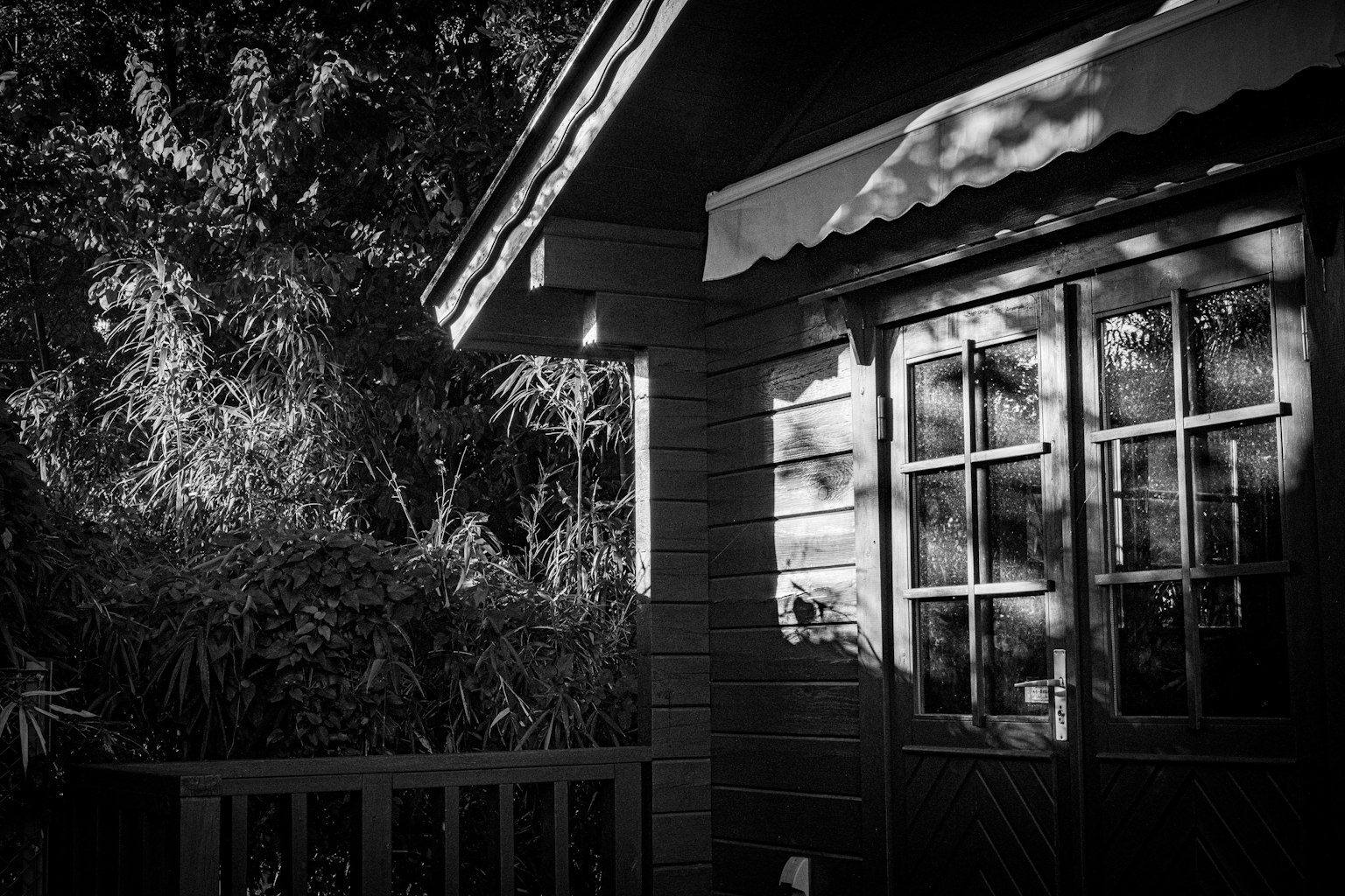 Monochrome Foto einer Holzhausfassade mit schönen Fensterschatten