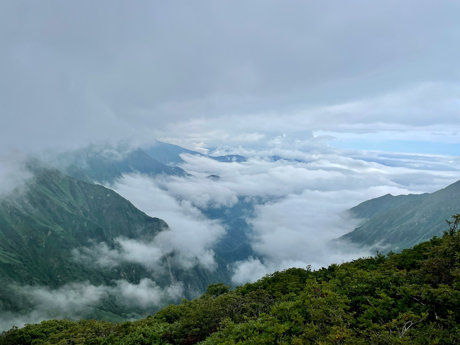 Schöne Landschaft mit in Nebel gehüllten Bergen und Wolkenmeer