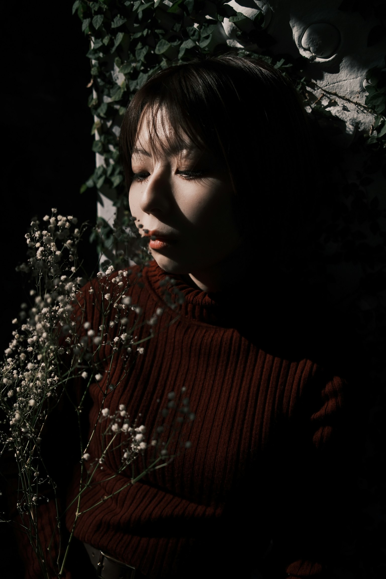 暗い背景に花を持つ女性のポートレート