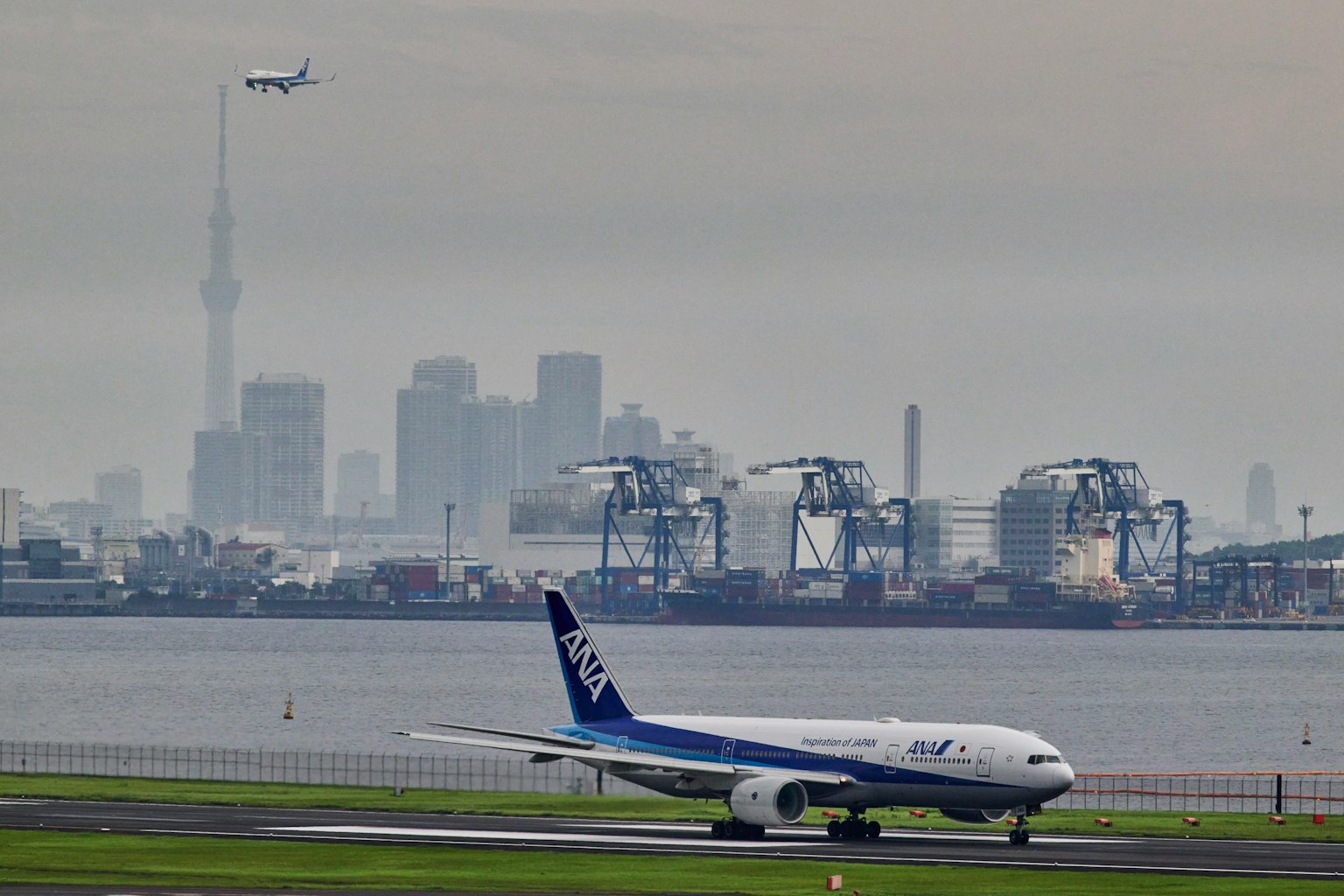 在東京灣旁的機場起飛的飛機，背景是東京晴空塔