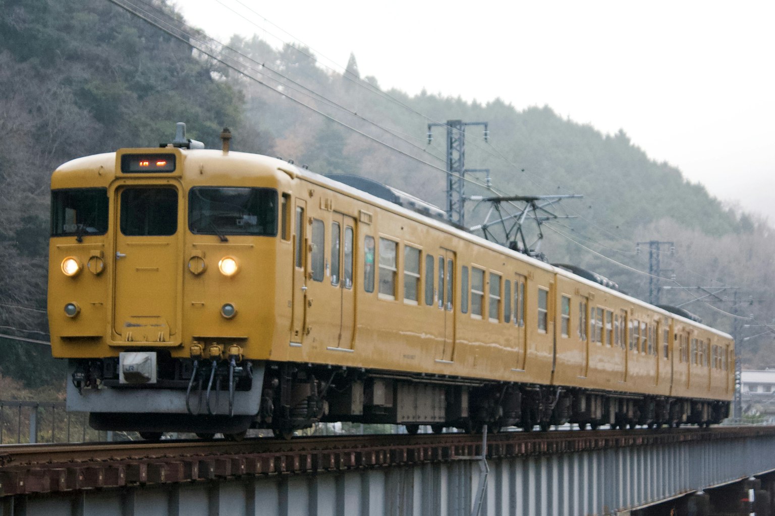 Yellow train traveling on the tracks