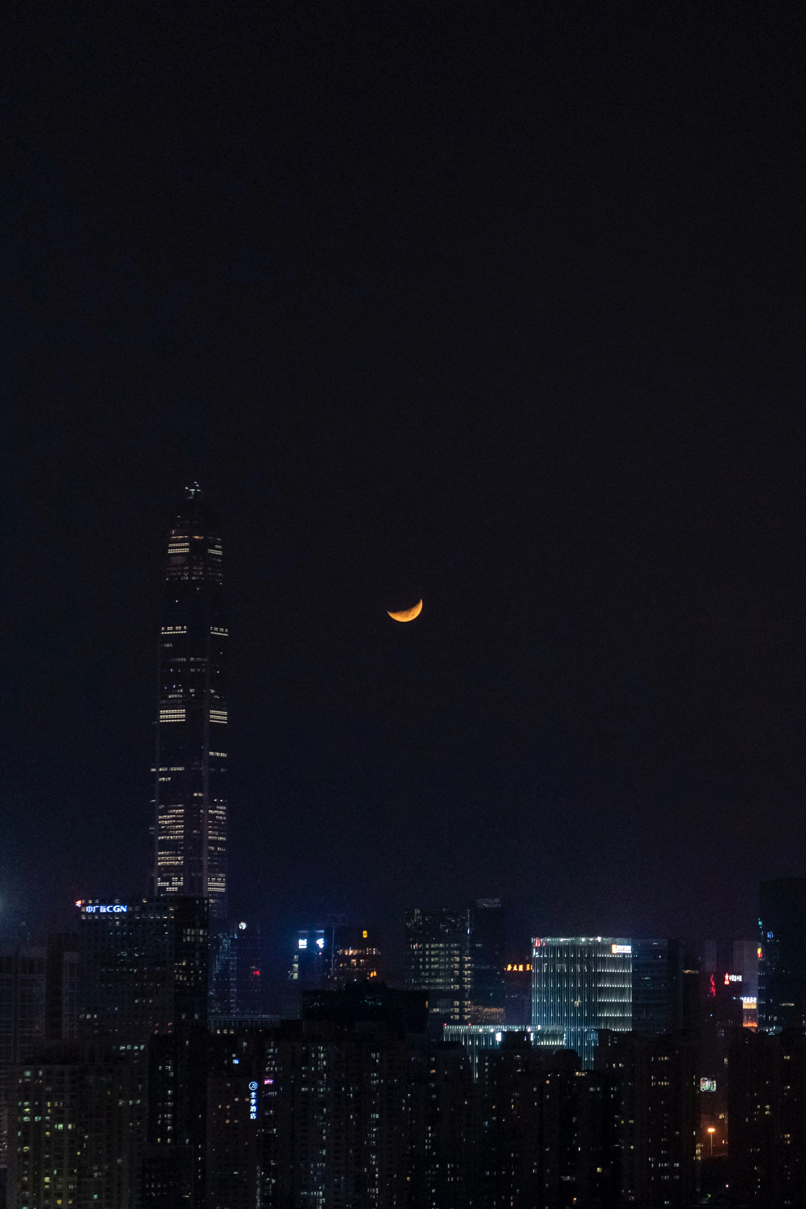 深圳の夜空に浮かぶ月と高層ビル群
