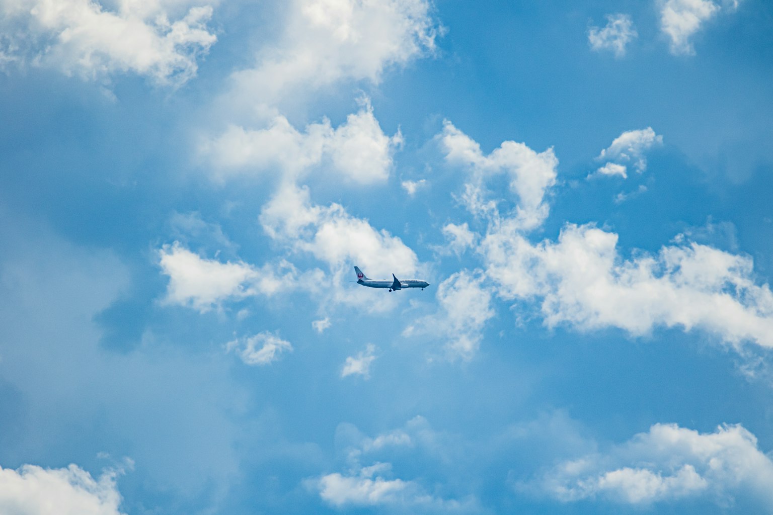 飛機飛翔在藍天和白雲中