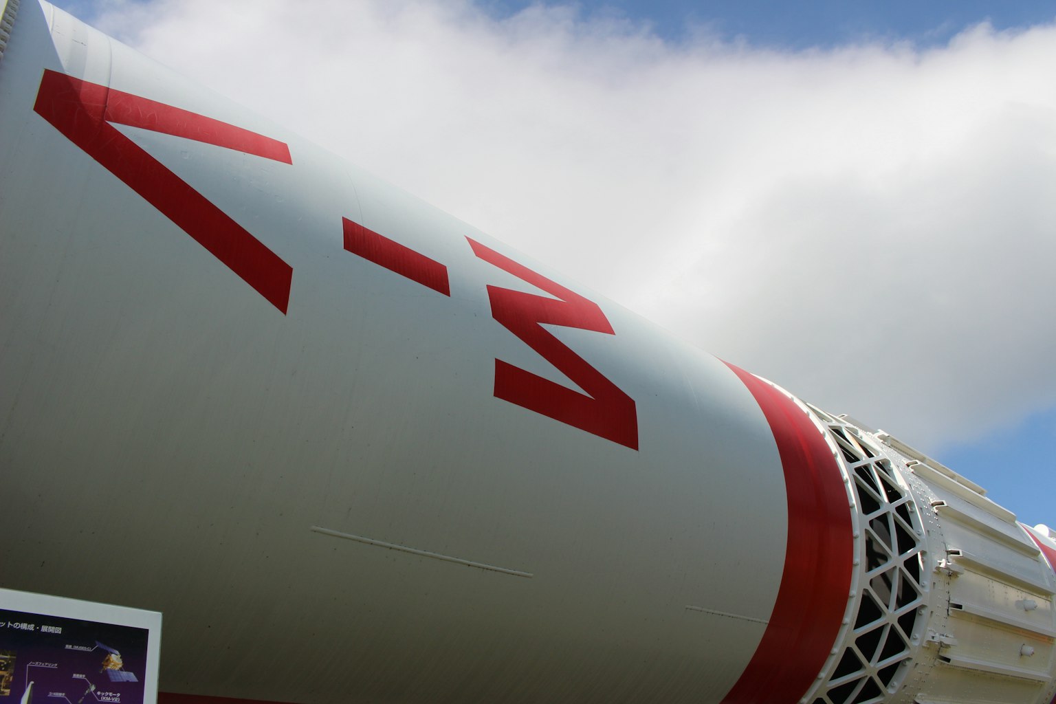 로켓의 클로즈업으로 흰색 본체에 빨간색 마크가 있는 모습