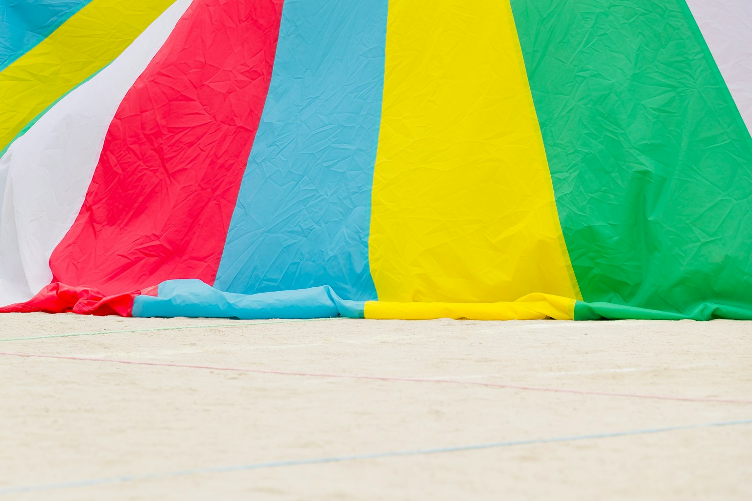 Bunte Stoffe hängen an einem Sandstrand