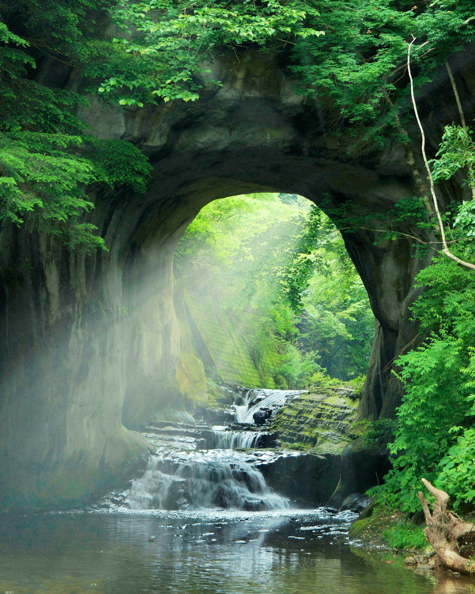 被綠色環繞的自然隧道和小瀑布