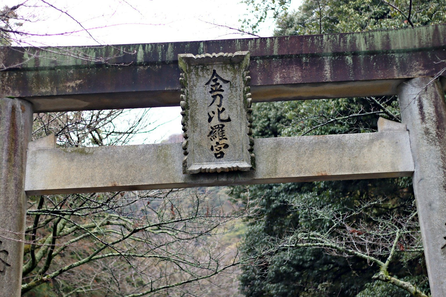 Ein alter Torii mit einer Inschrift auf einer Steinplatte