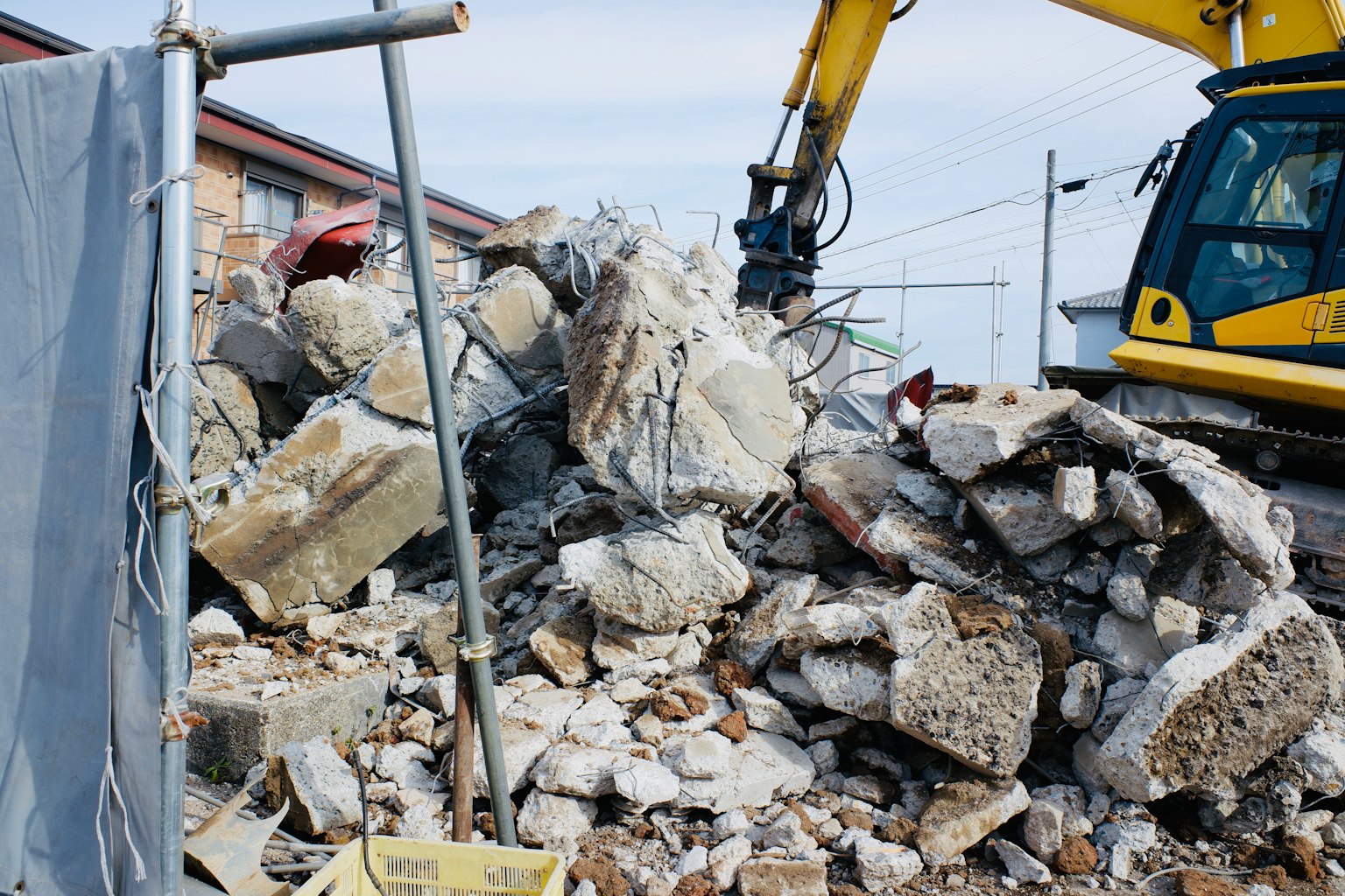 Un cumulo di detriti di cemento demolito in un cantiere con macchinari pesanti