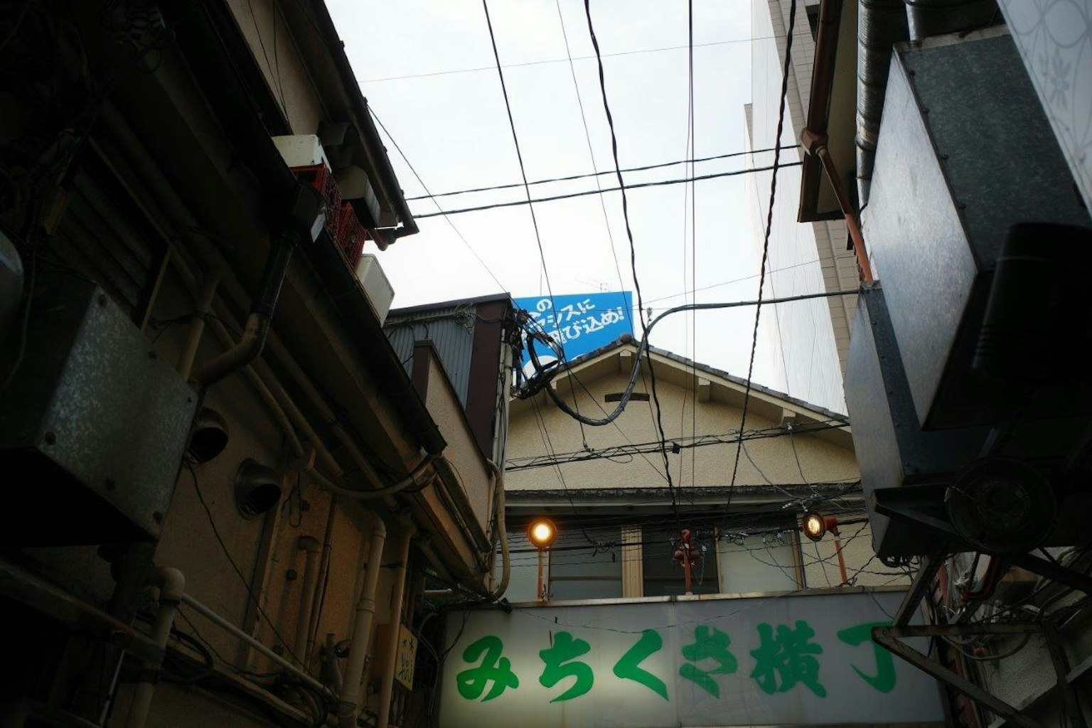 View of a narrow alley with a Japanese building and sign