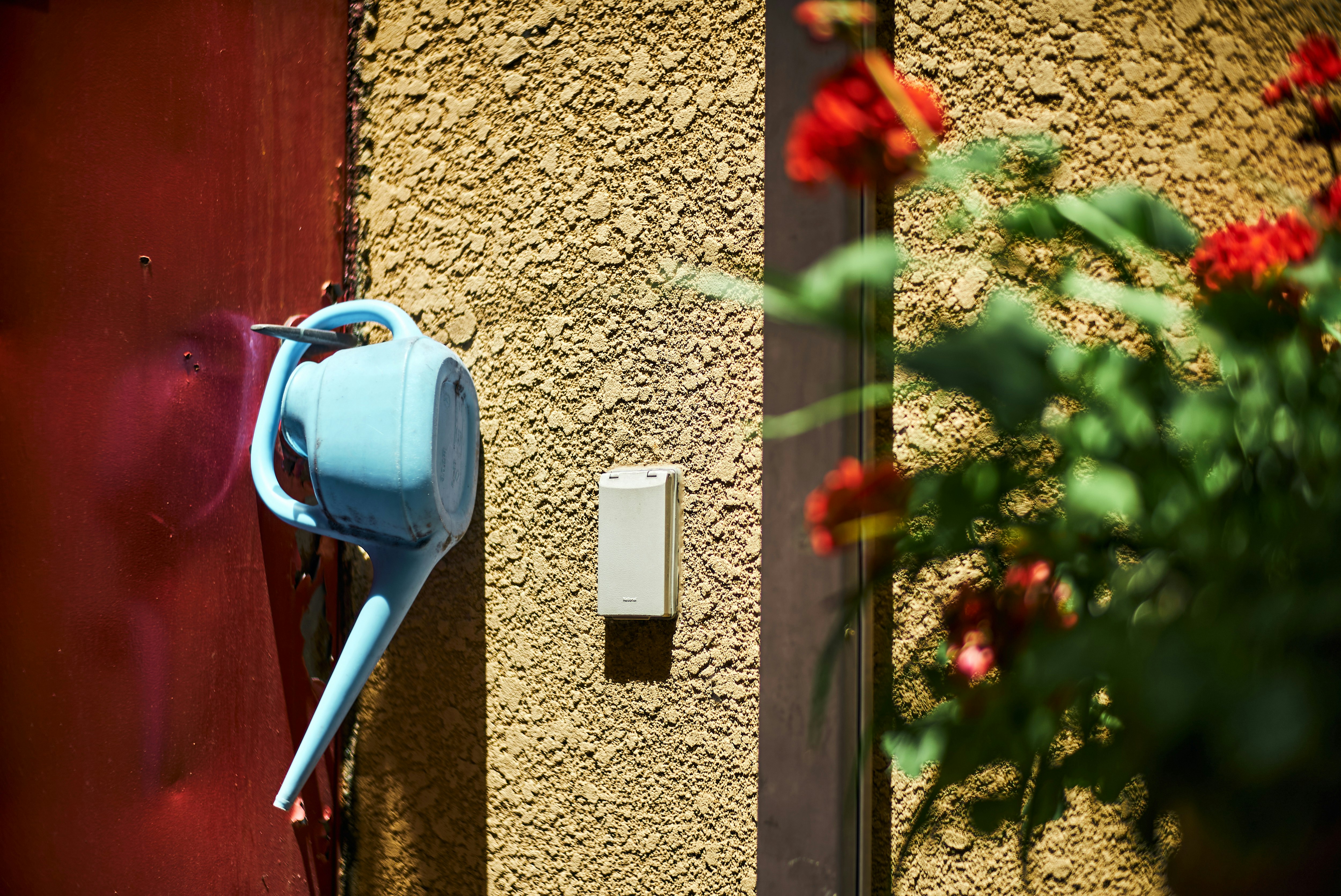 blue hose reel and outdoor power box mounted on a wall