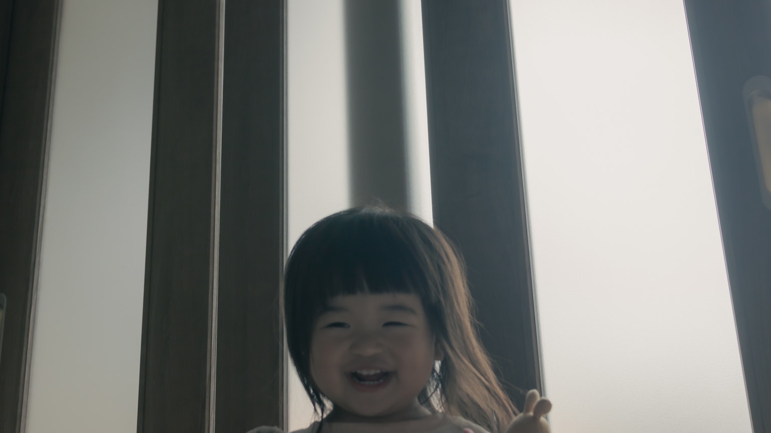 เด็กหญิงยิ้มใกล้หน้าต่างสว่าง