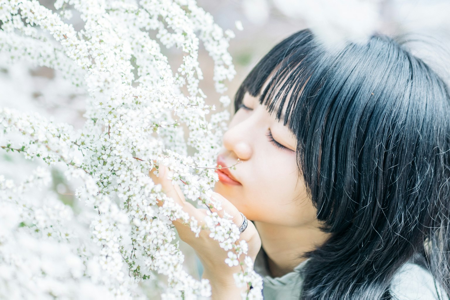 Profilo di una donna che tocca delicatamente fiori bianchi