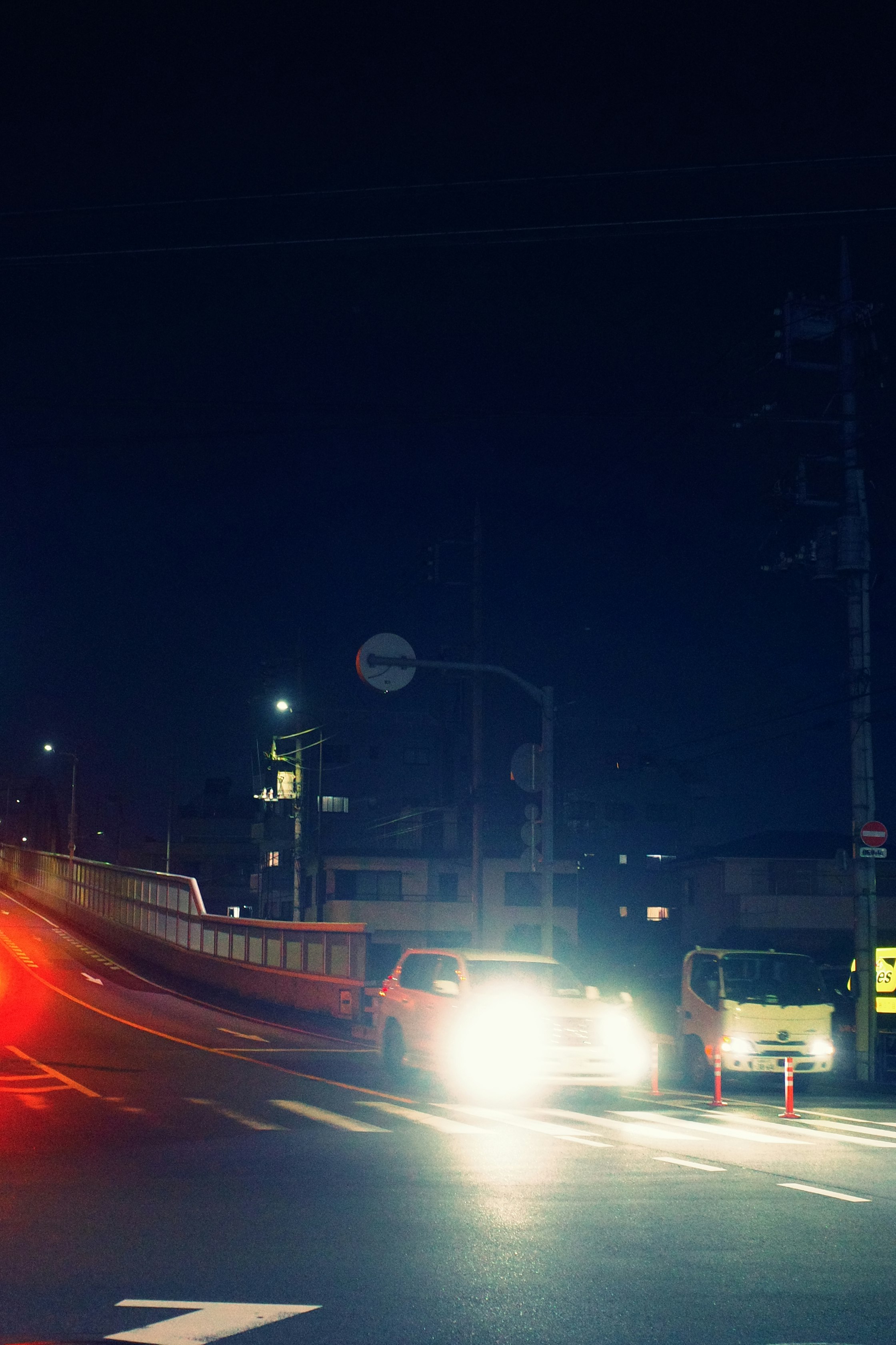 夜の交差点を走る車の光跡