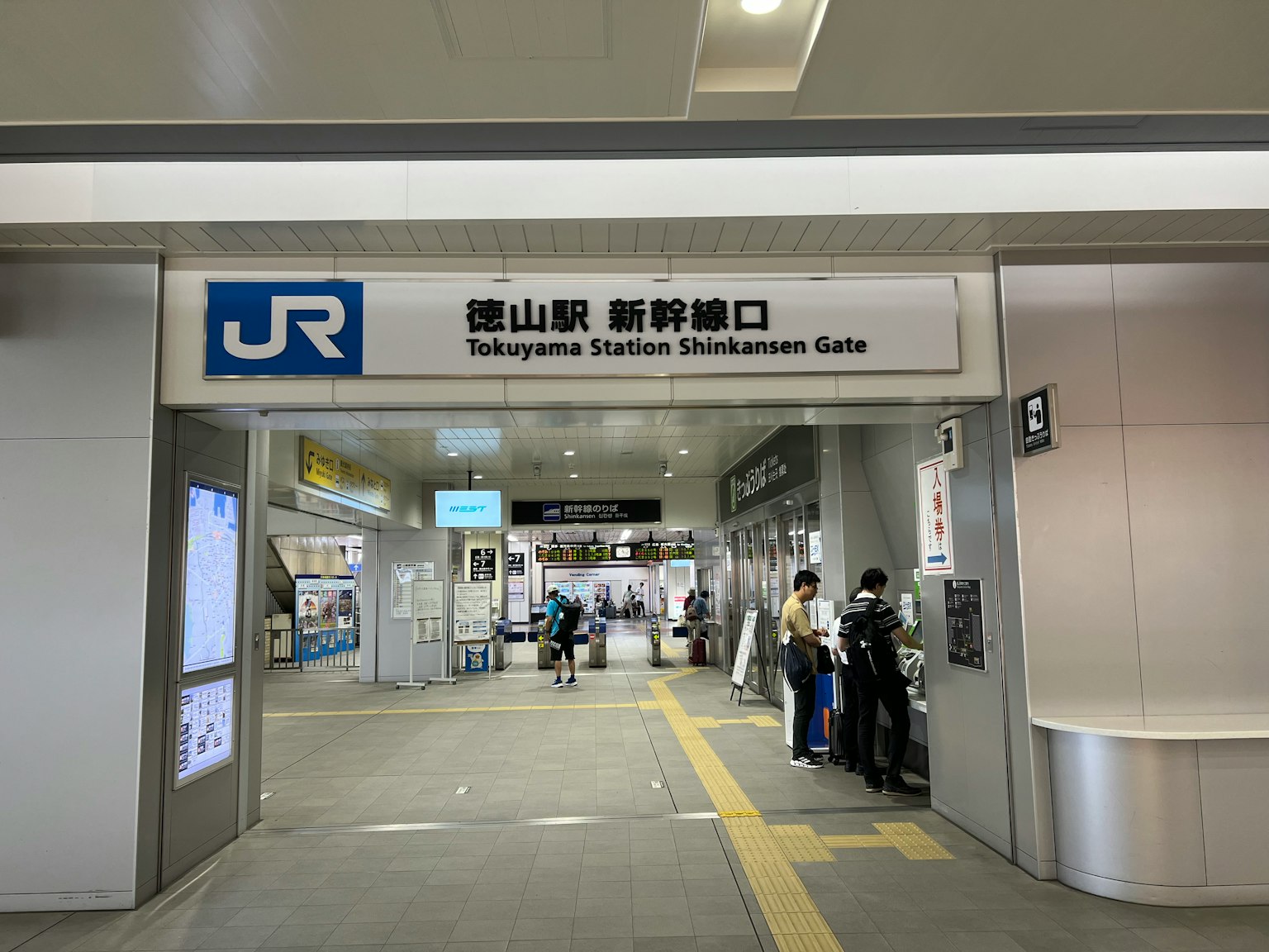 Entrance sign for Tokyo Station Shinkansen Gate with people