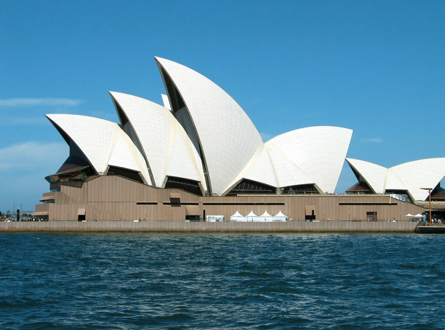 Sydney Opera House dengan atap putih berbentuk layar yang khas di bawah langit biru