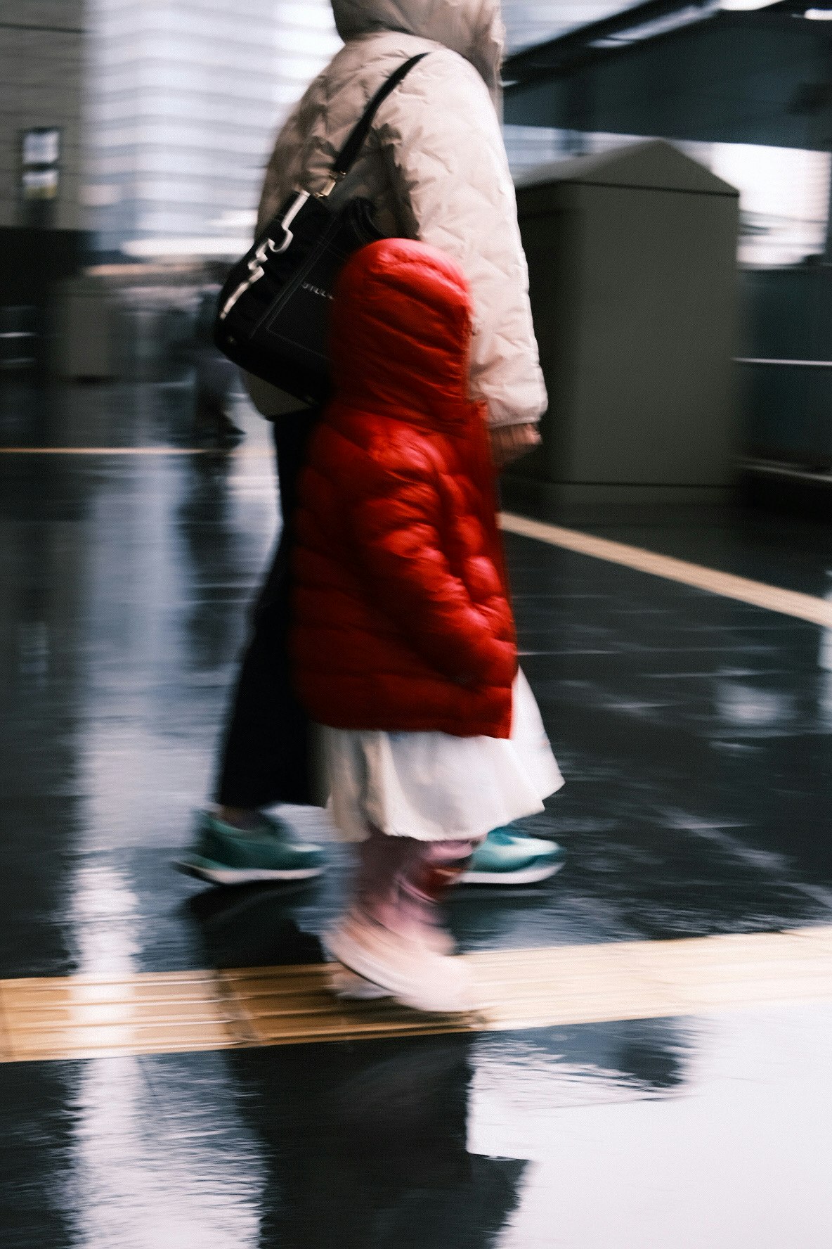 Una persona con abrigo de invierno caminando por un pasillo interior