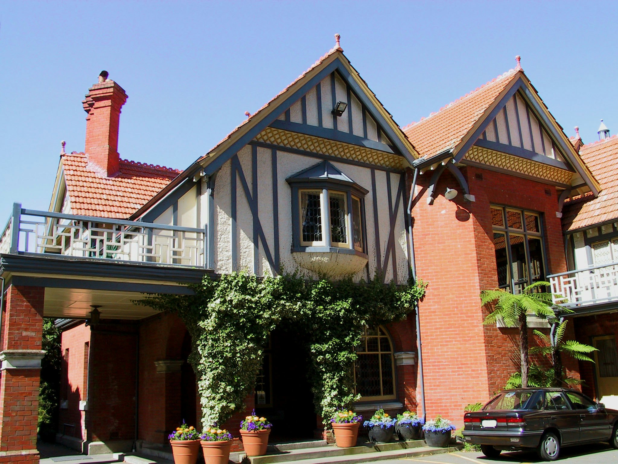 Entrada de una casa de ladrillo y estilo de entramado con un coche