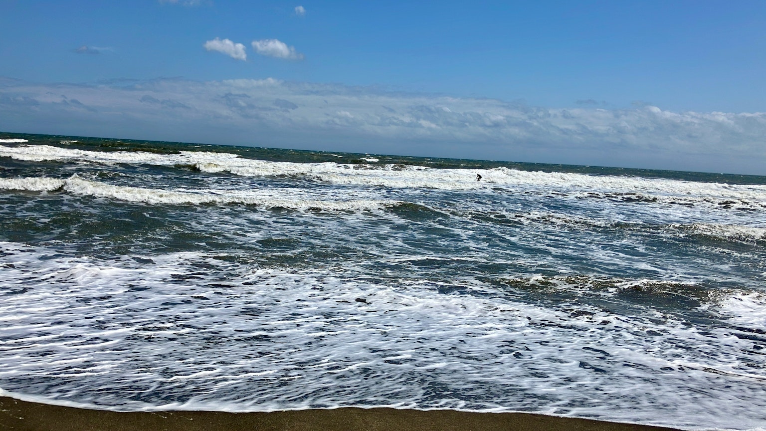 Panoramablick auf blaue Ozeanwellen, die an den Strand brechen
