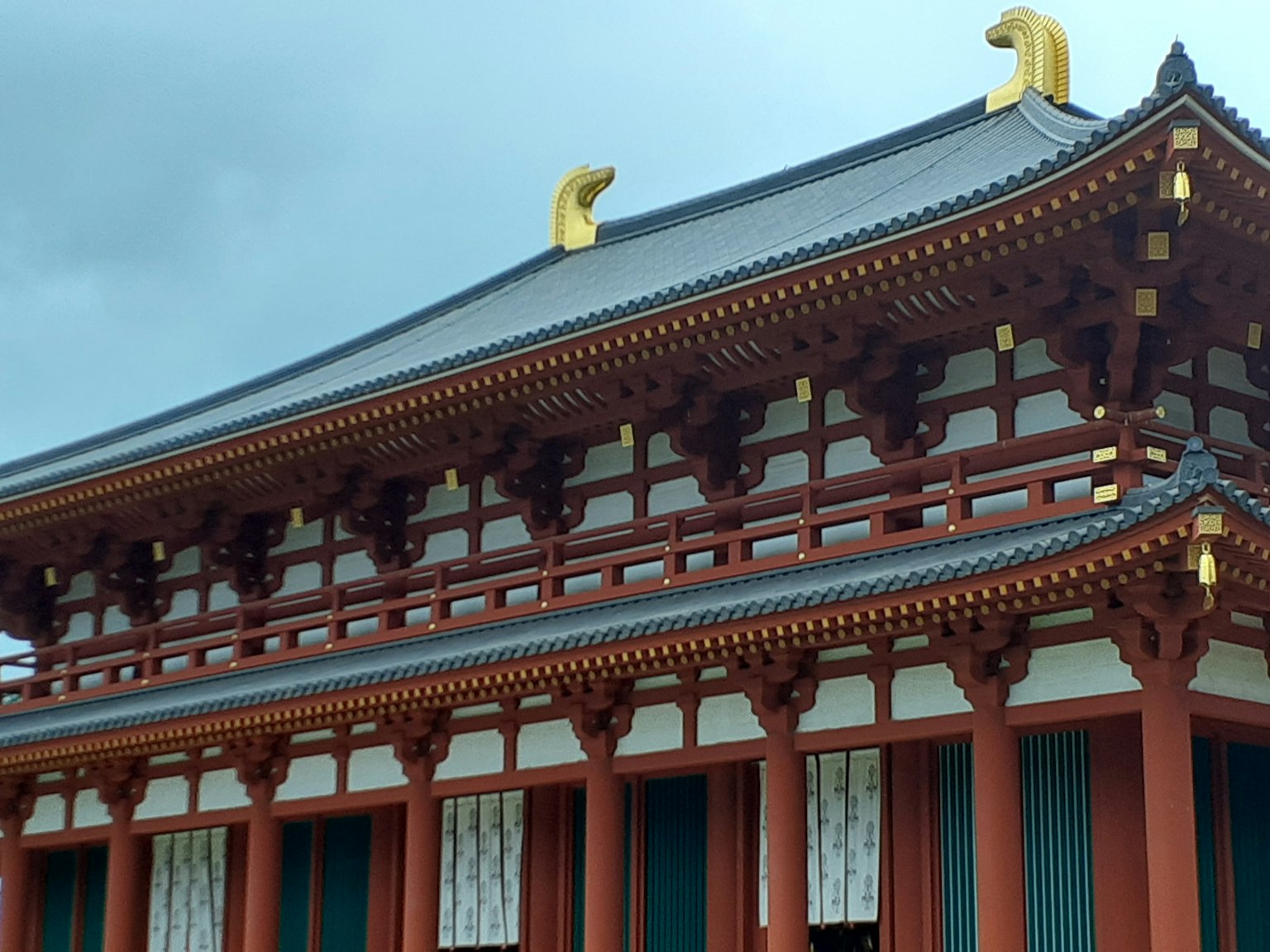 傳統日本建築，屋頂上有美麗的紅色柱子和金色裝飾