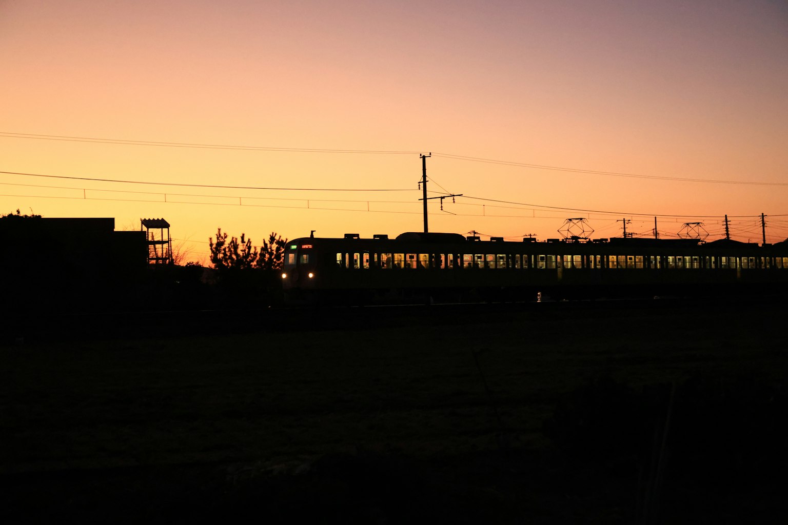 Silhouette di un treno e edifici al tramonto