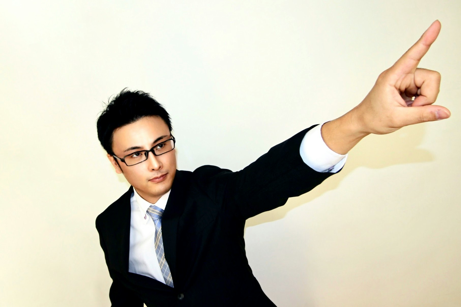 指を使ってジェスチャーするスーツ姿の男性