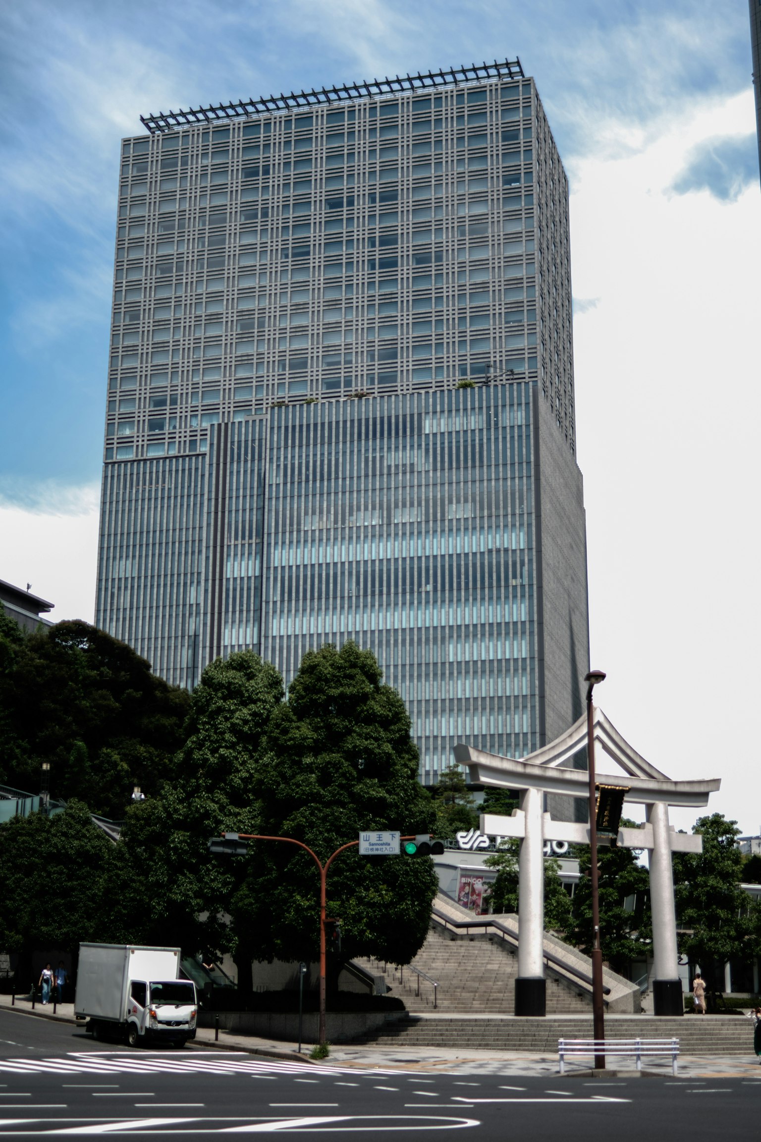 Eine Stadtansicht mit einem Wolkenkratzer und einem traditionellen Torii-Tor