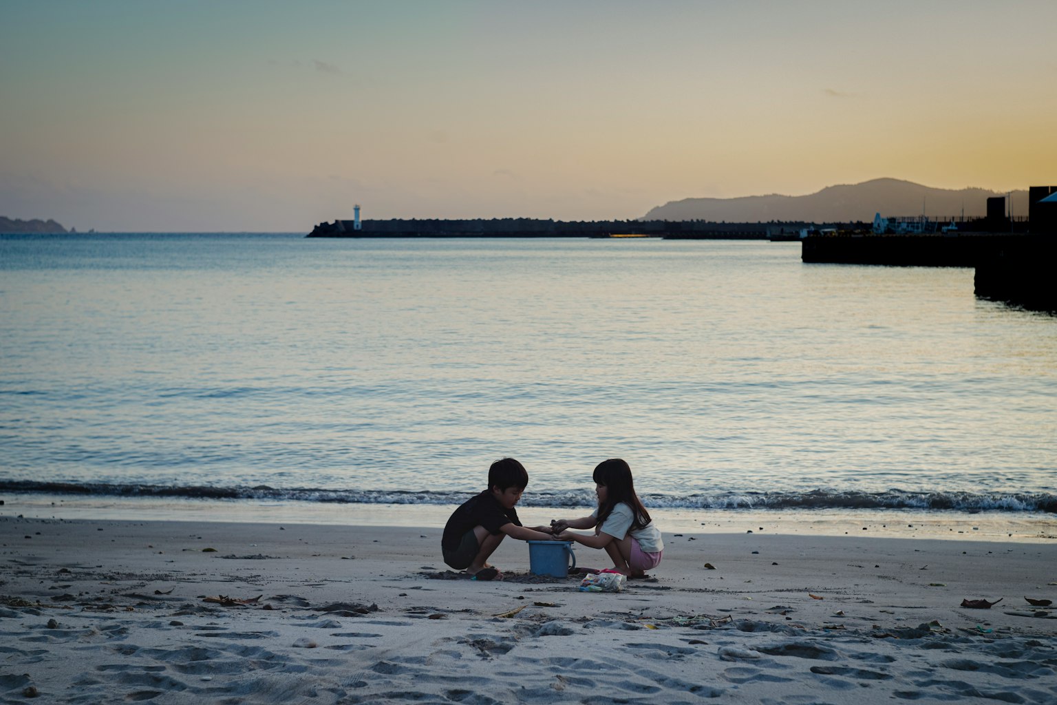 Bambini che giocano sulla spiaggia al tramonto