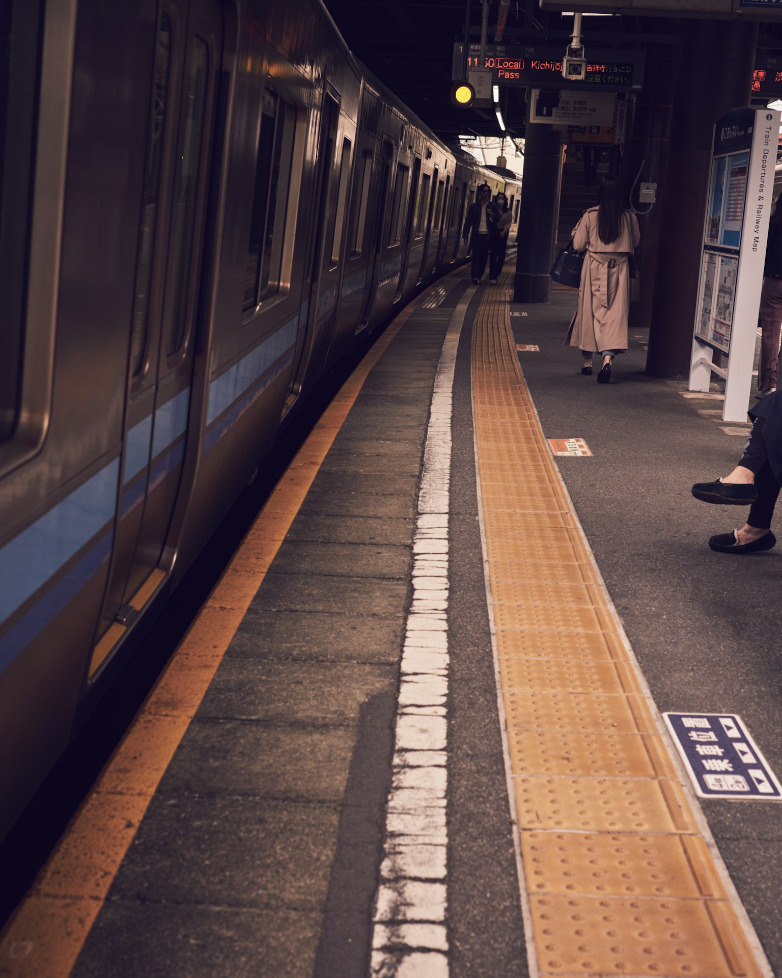 Tren parado en una plataforma de estación con pasajeros