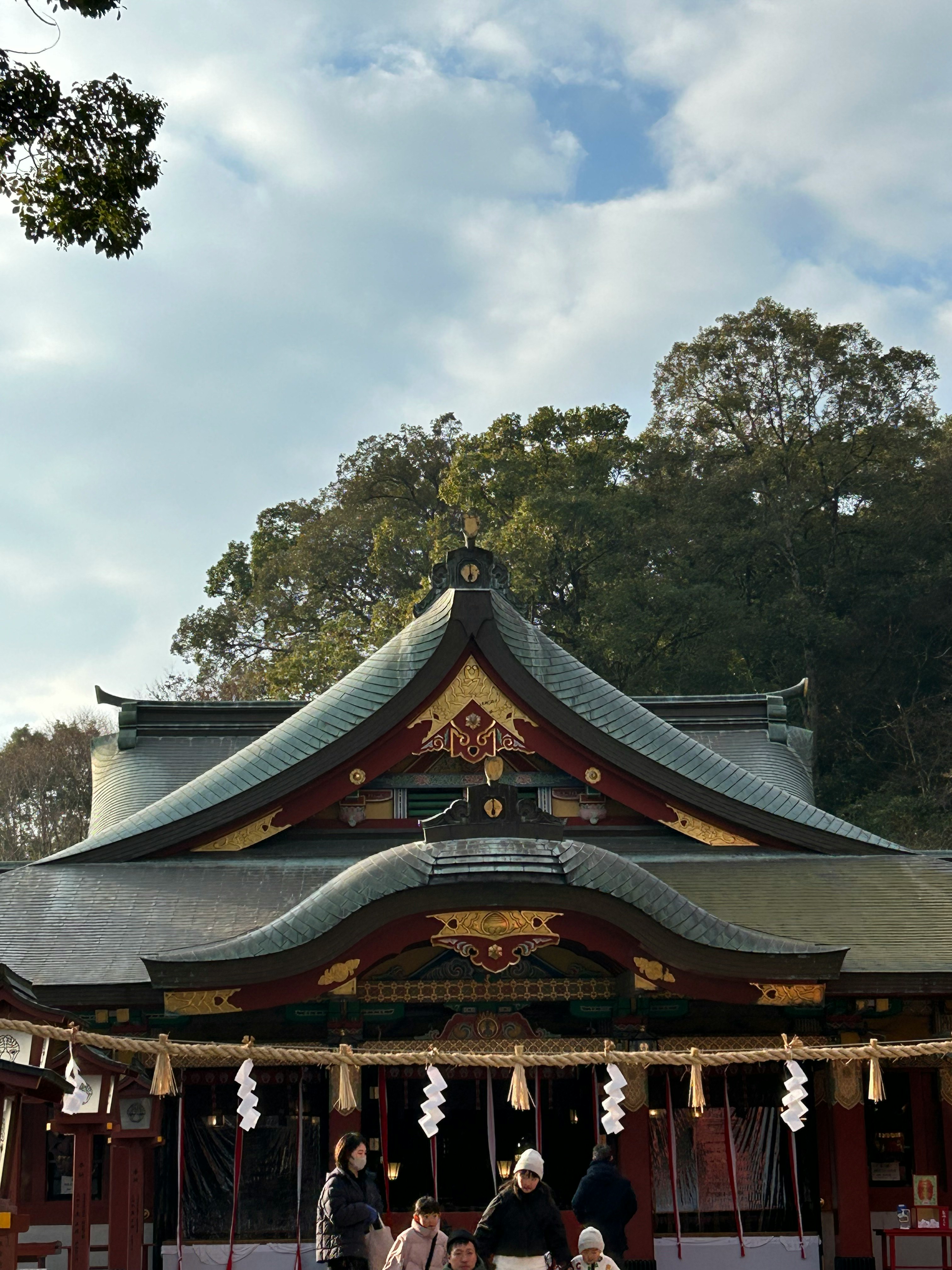 Grande santuario shinto con corde shimenawa circondato da foresta