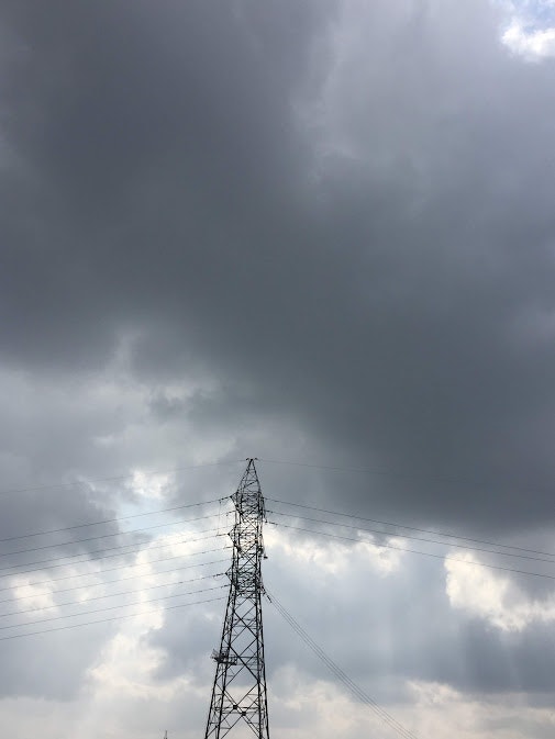 cloudy sky with an electricity transmission tower