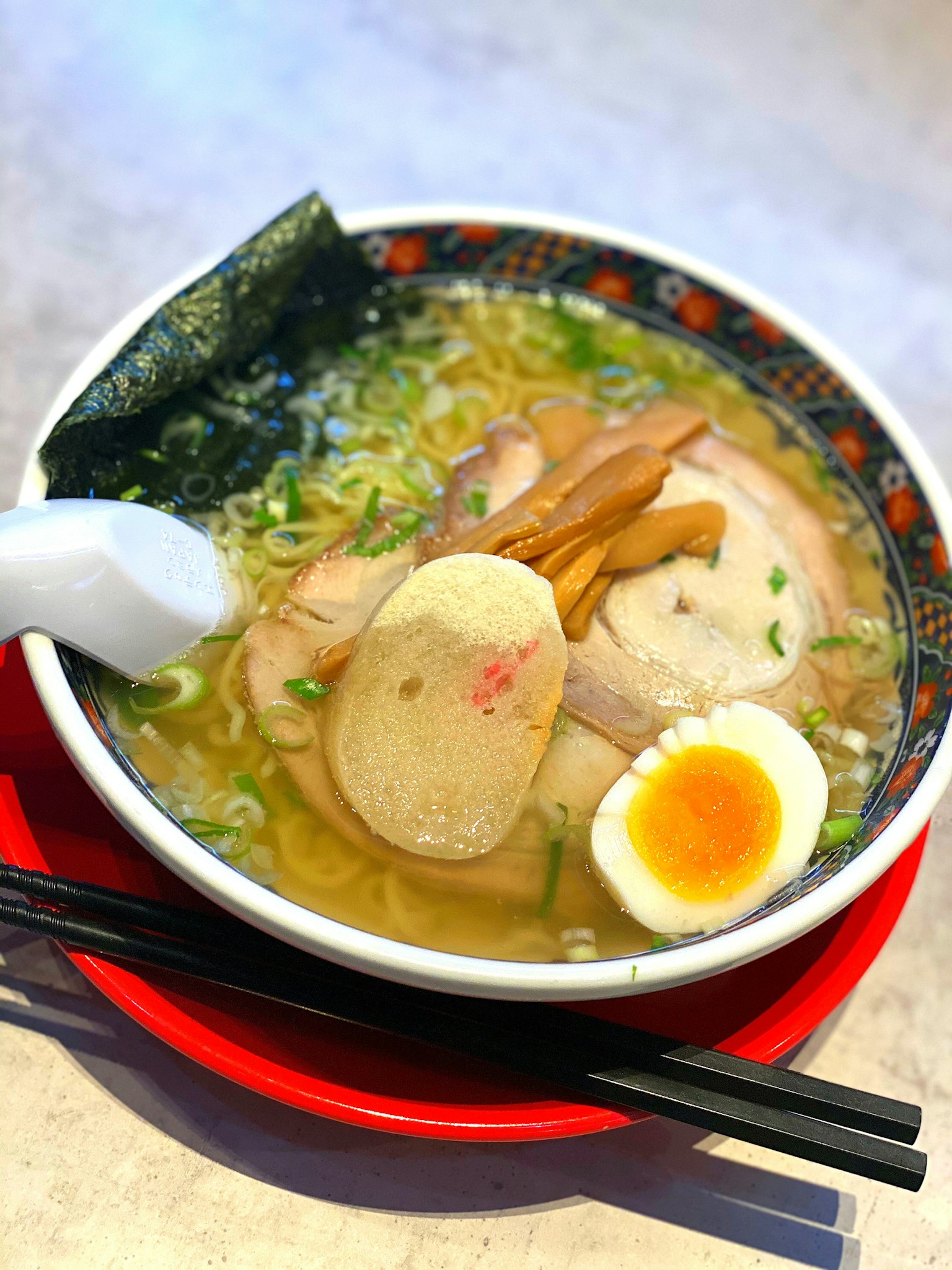Mangkuk ramen dengan daging babi iris, tunas bambu, dan telur setengah matang