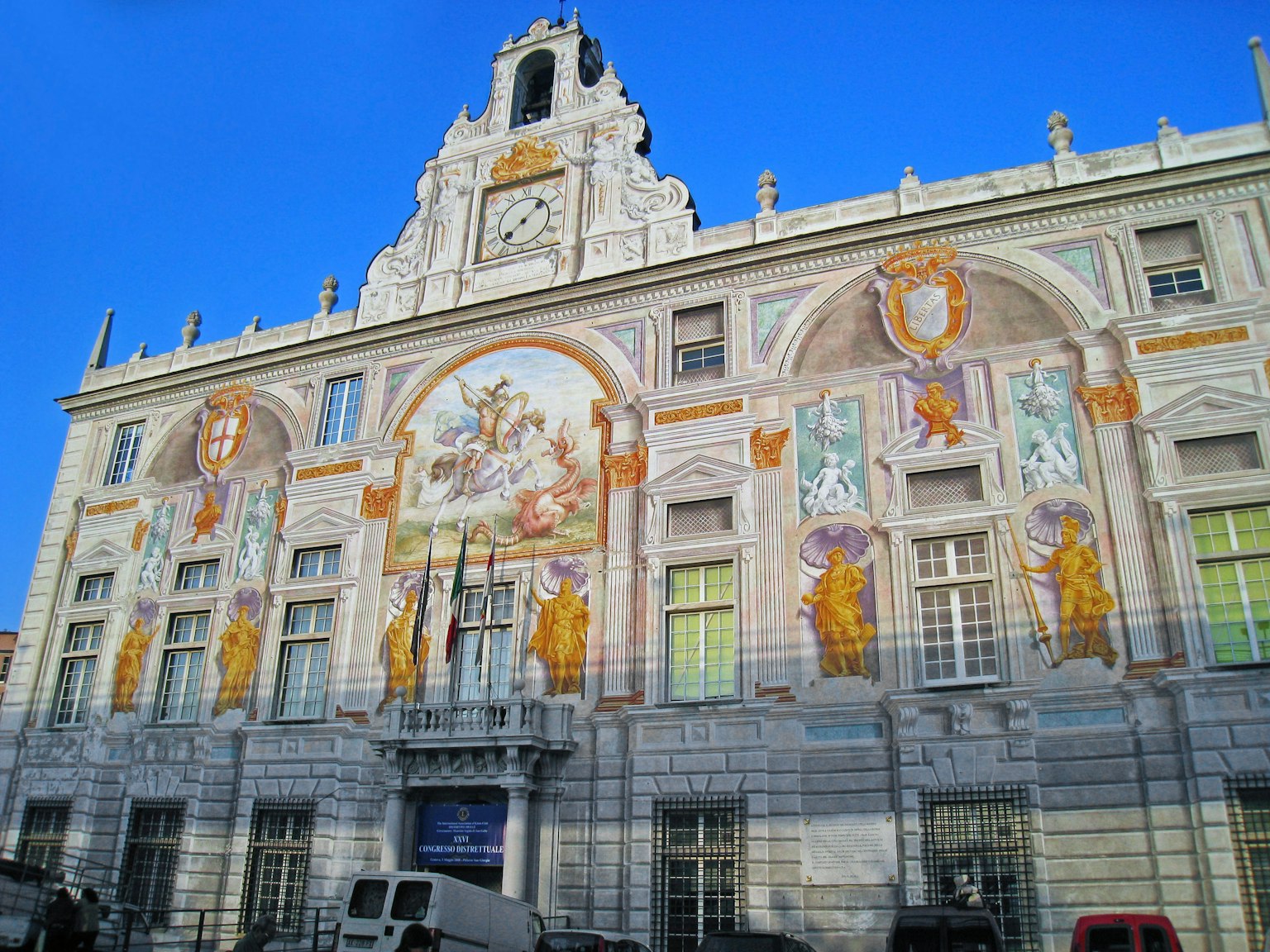 Façade d'un bâtiment historique ornée de magnifiques fresques sous un ciel bleu clair