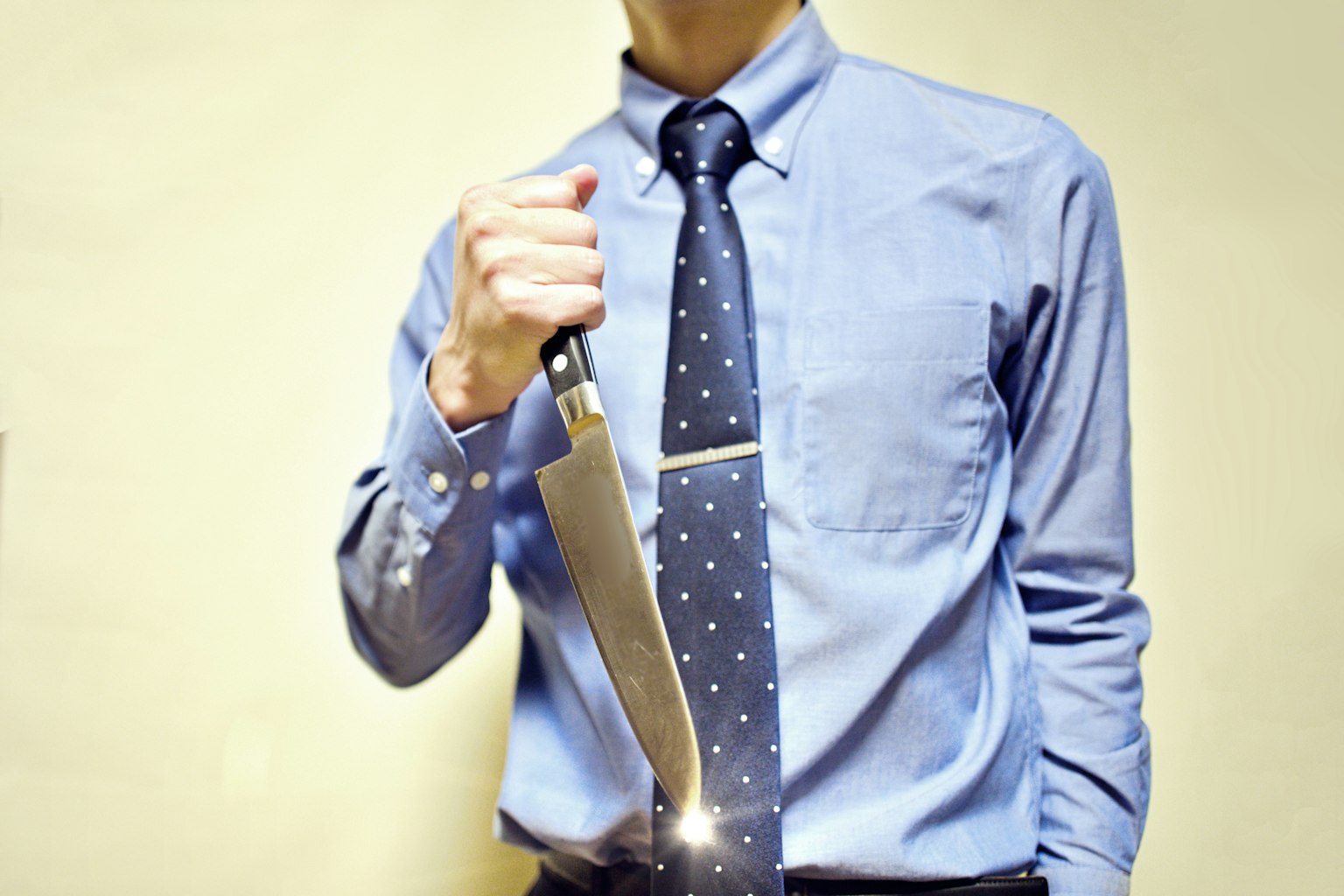 Un hombre en traje sosteniendo un cuchillo