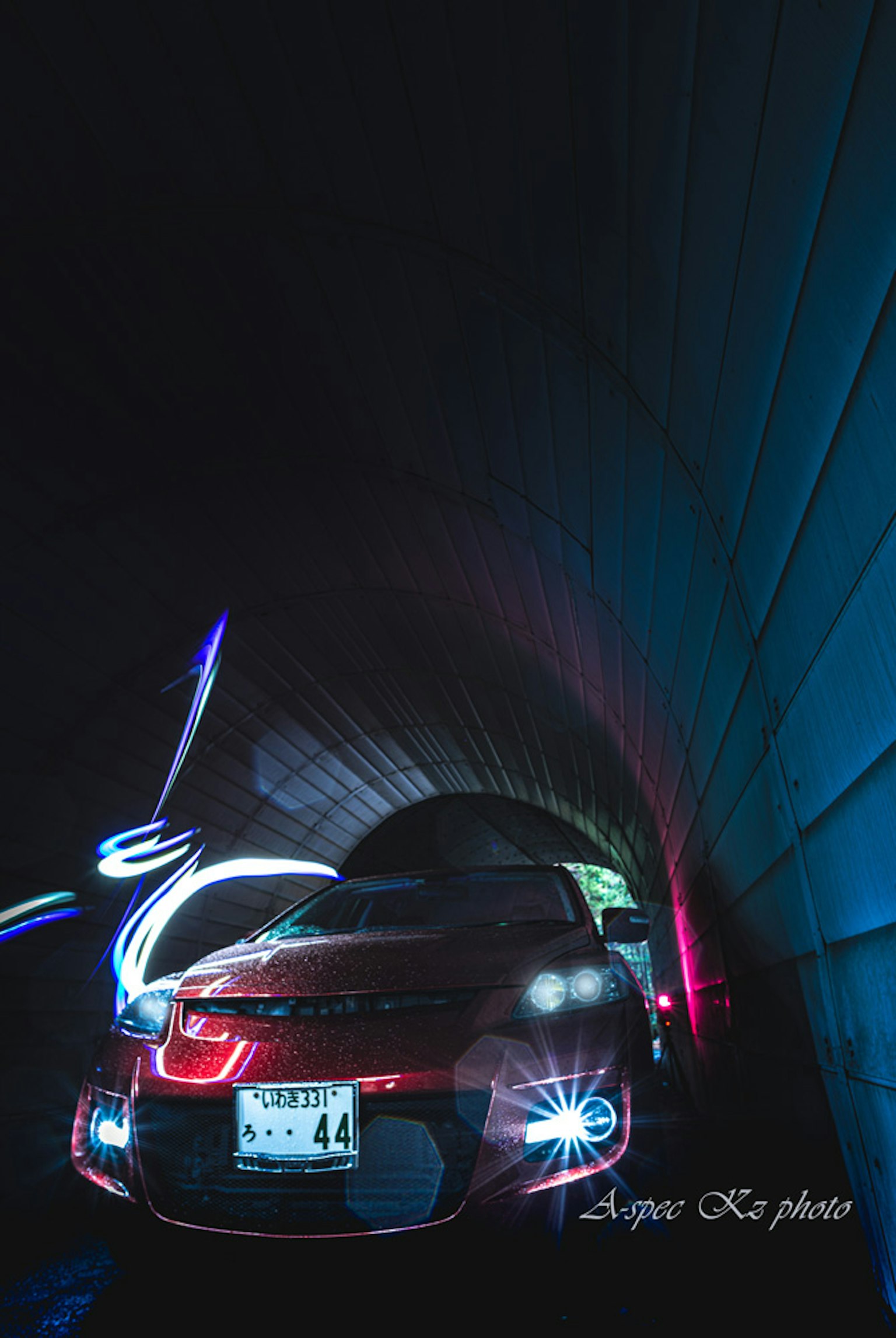 Image of a red car emitting light inside a tunnel