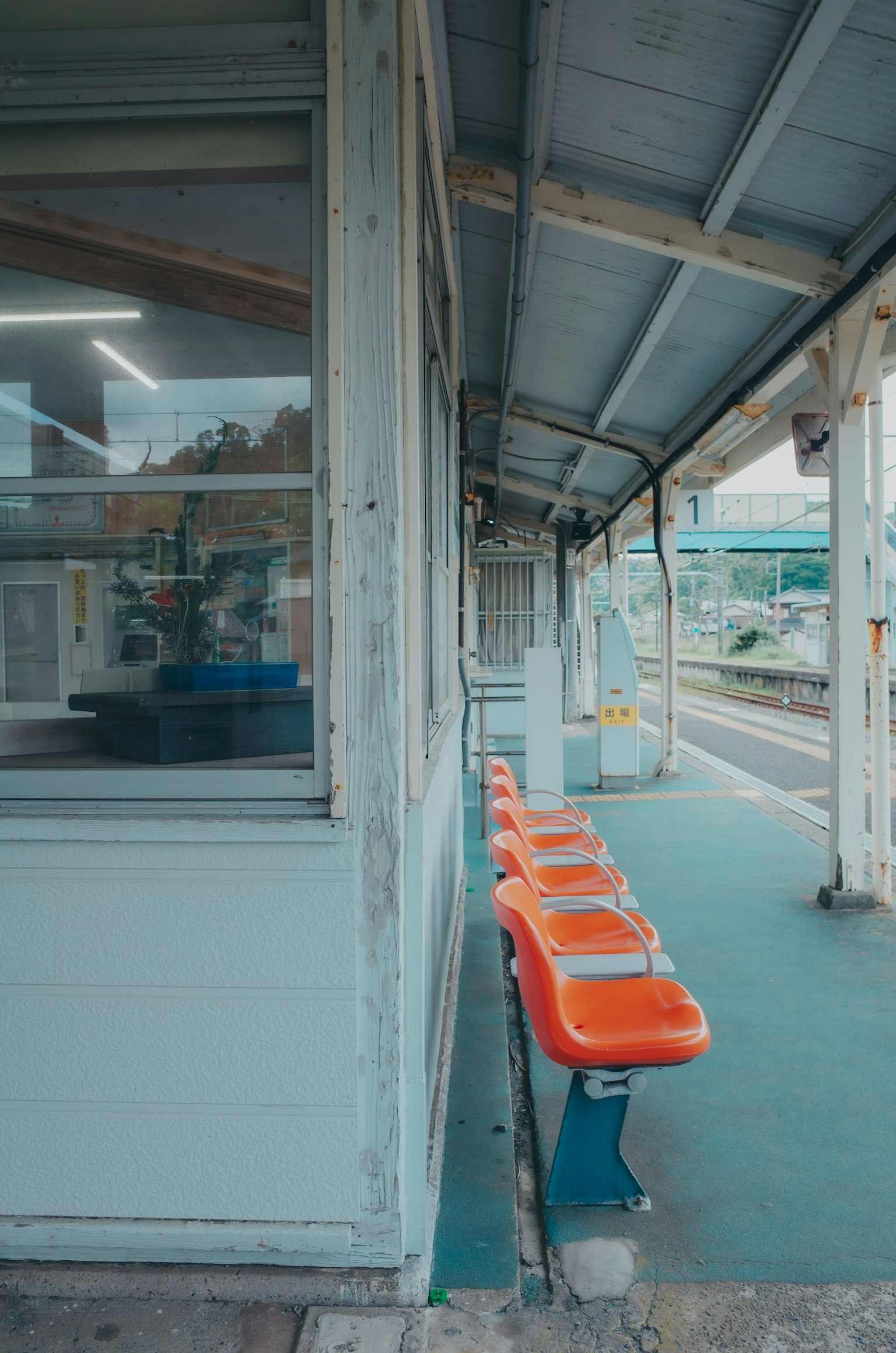 Ghế màu cam trong khu vực chờ của nhà ga với tường trắng