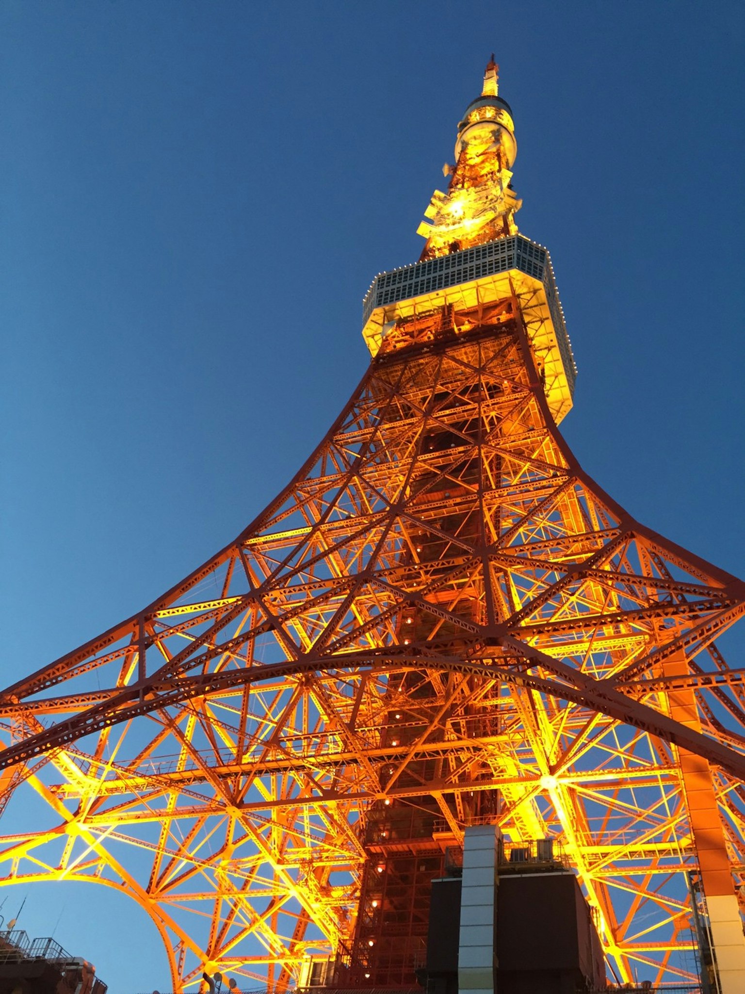 東京塔夜景，橙色閃耀的鋼鐵結構，藍色天空