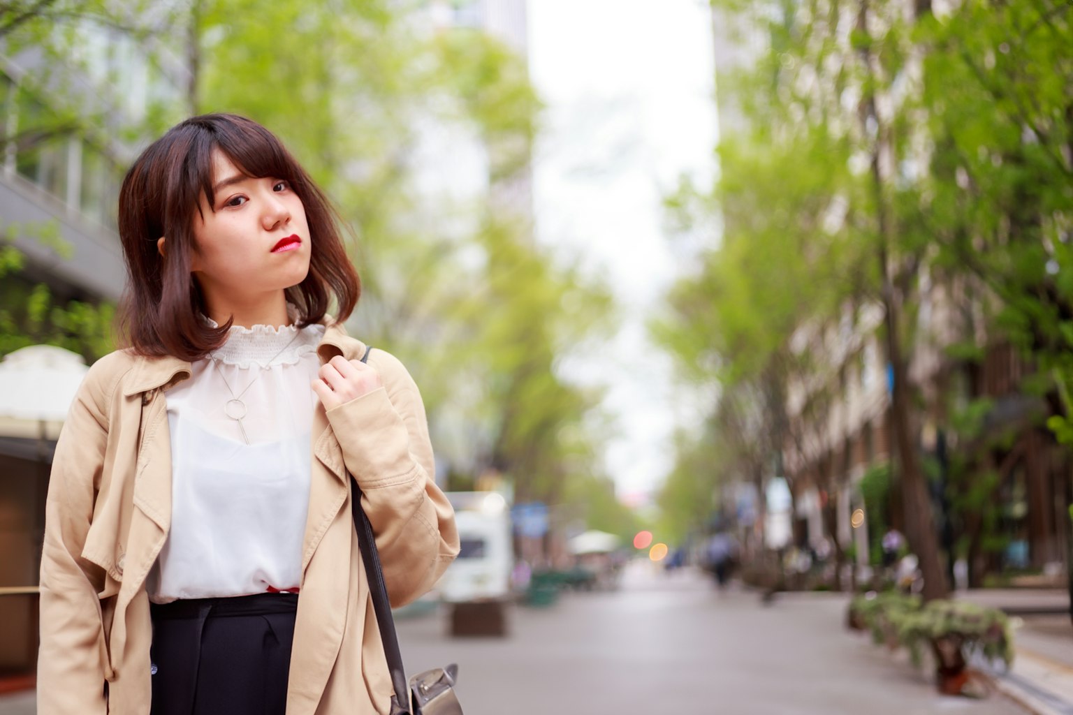 城市街道背景的女性肖像 春天的綠意為背景