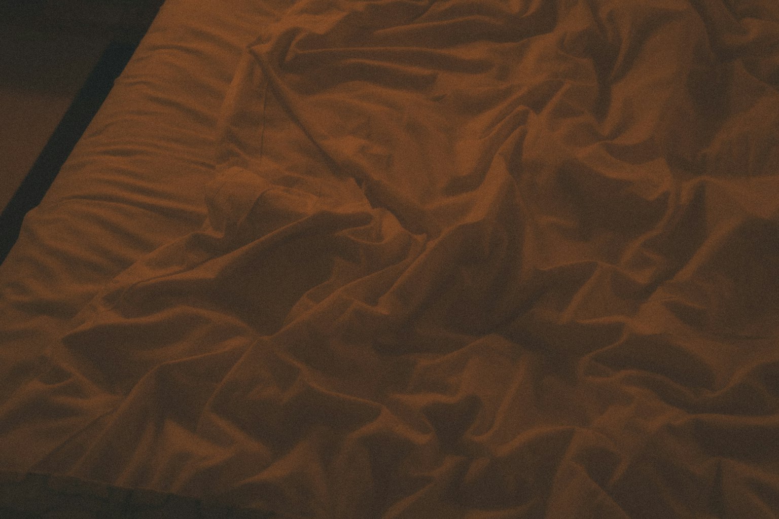 Nahaufnahme von zerknitterten Bettlaken auf einem Bett