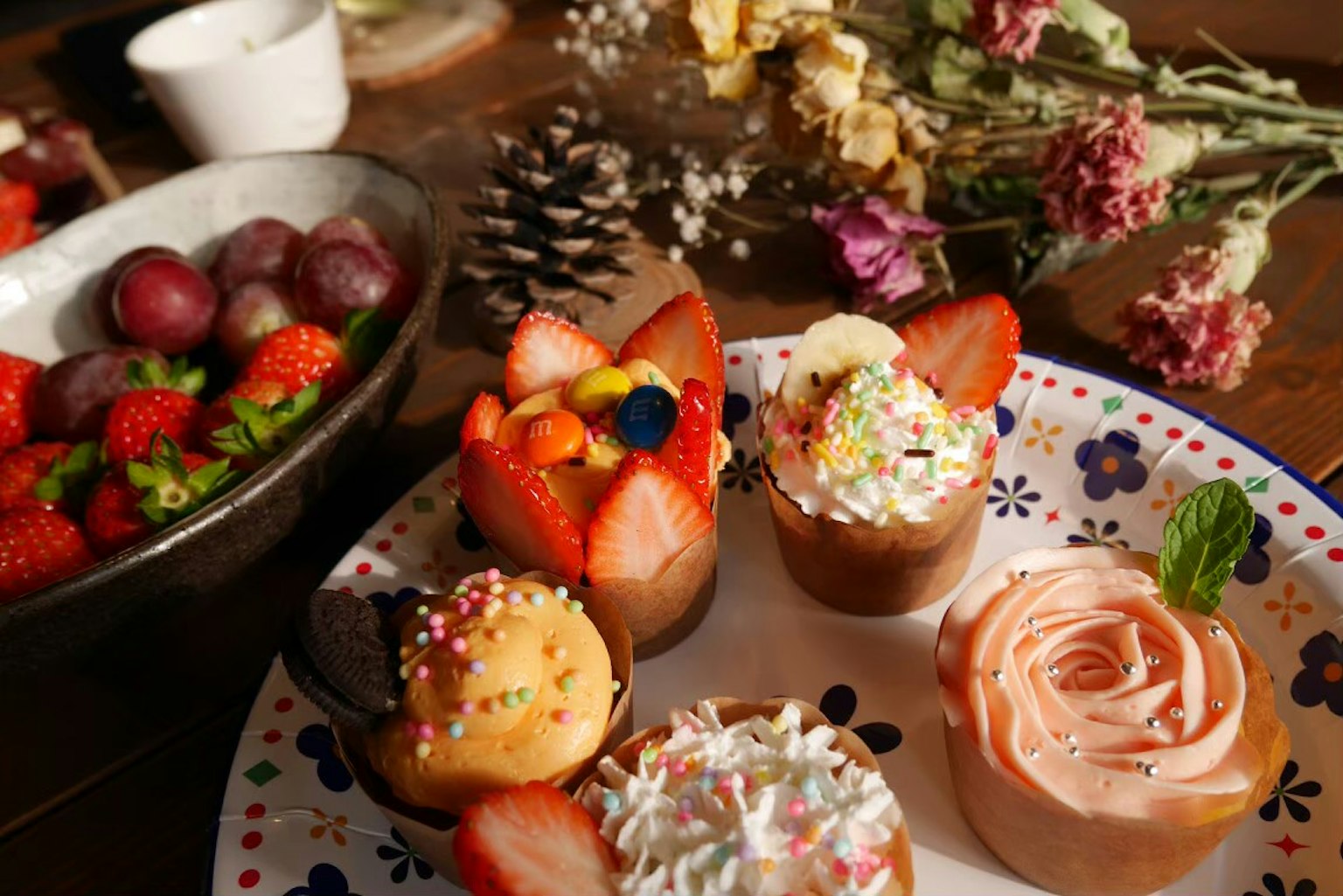 Colorful cupcakes and fresh fruits arranged on a beautiful table setting