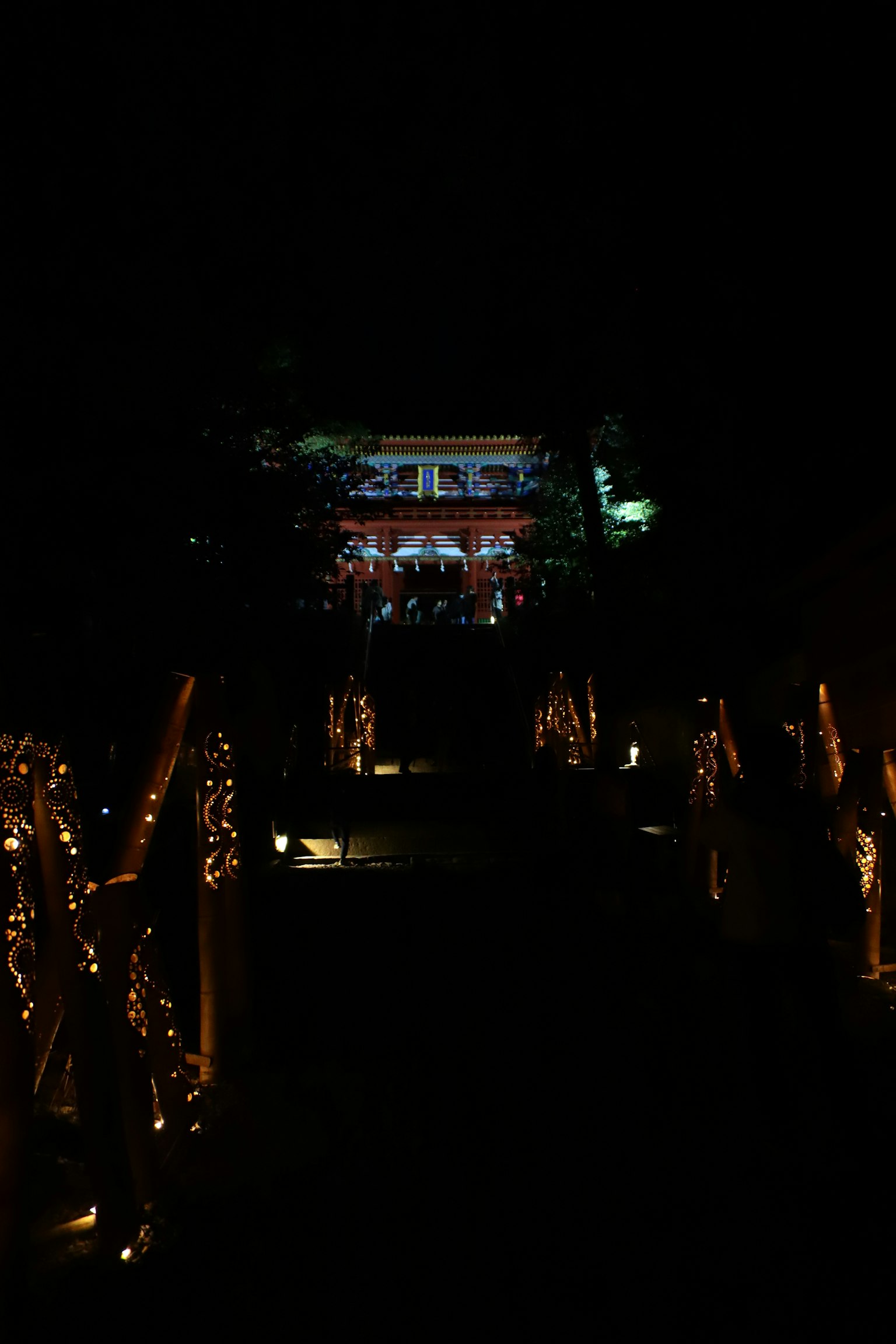 Sentiero illuminato di notte con un edificio sullo sfondo