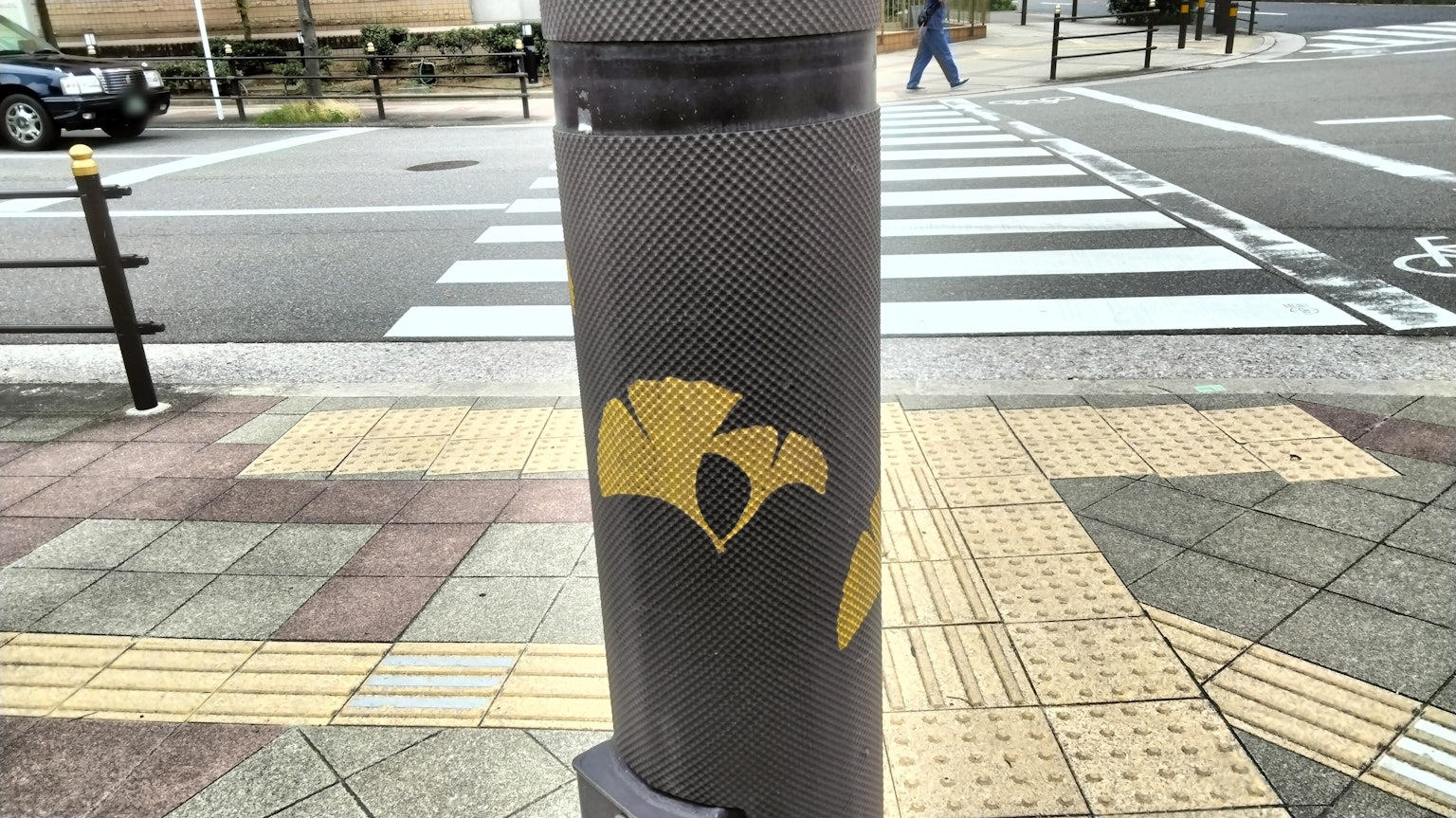 Design di foglia di ginkgo gialla su un palo del semaforo a un incrocio