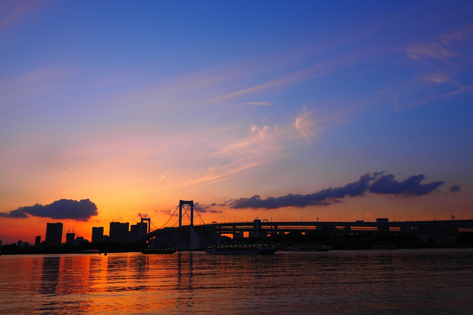 Tramonto sulla baia di Tokyo con skyline urbano in silhouette