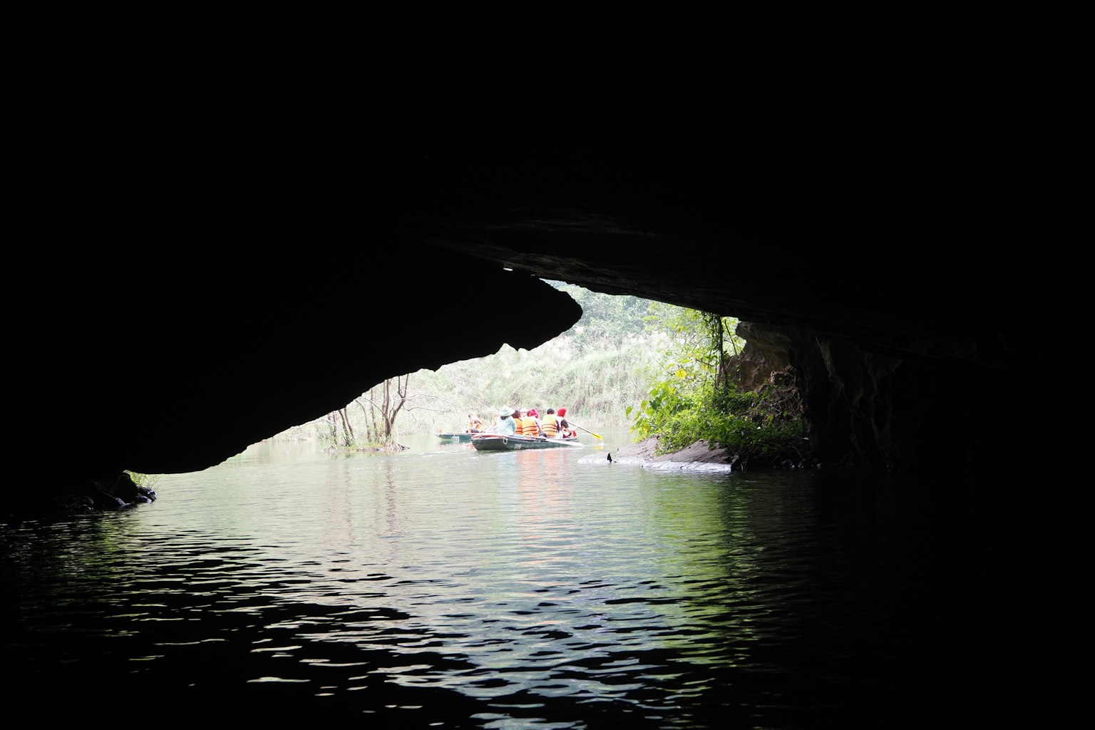 Vista di una superficie d'acqua serena e di una barca da una caverna buia