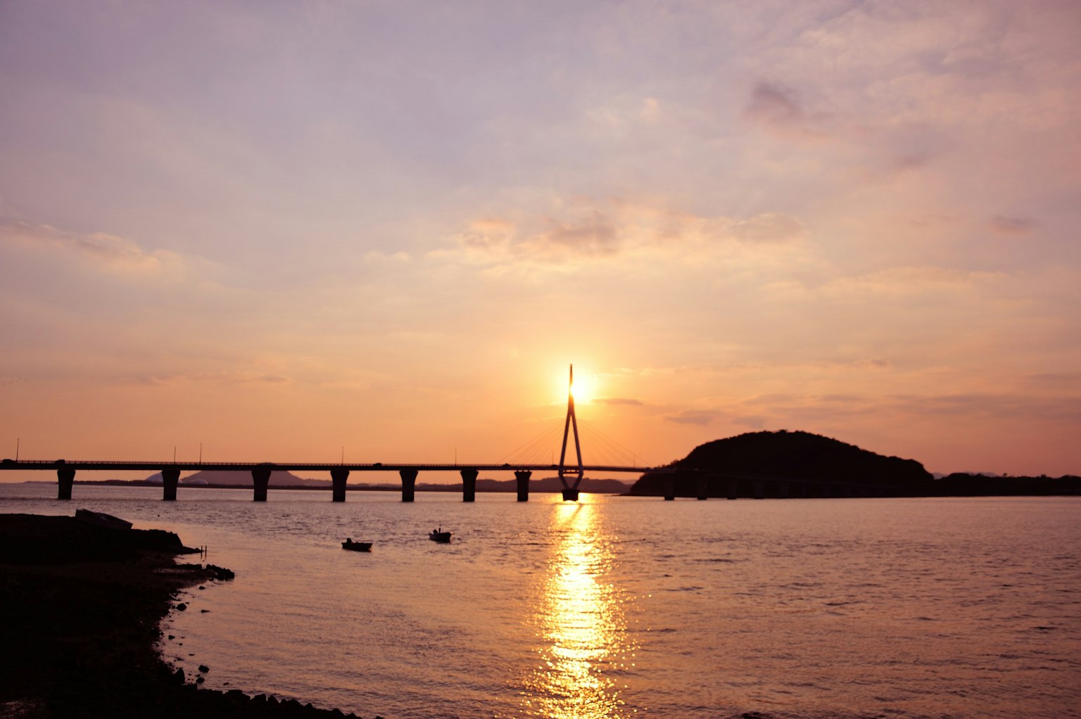 Scenic view of a river with a bridge at sunset