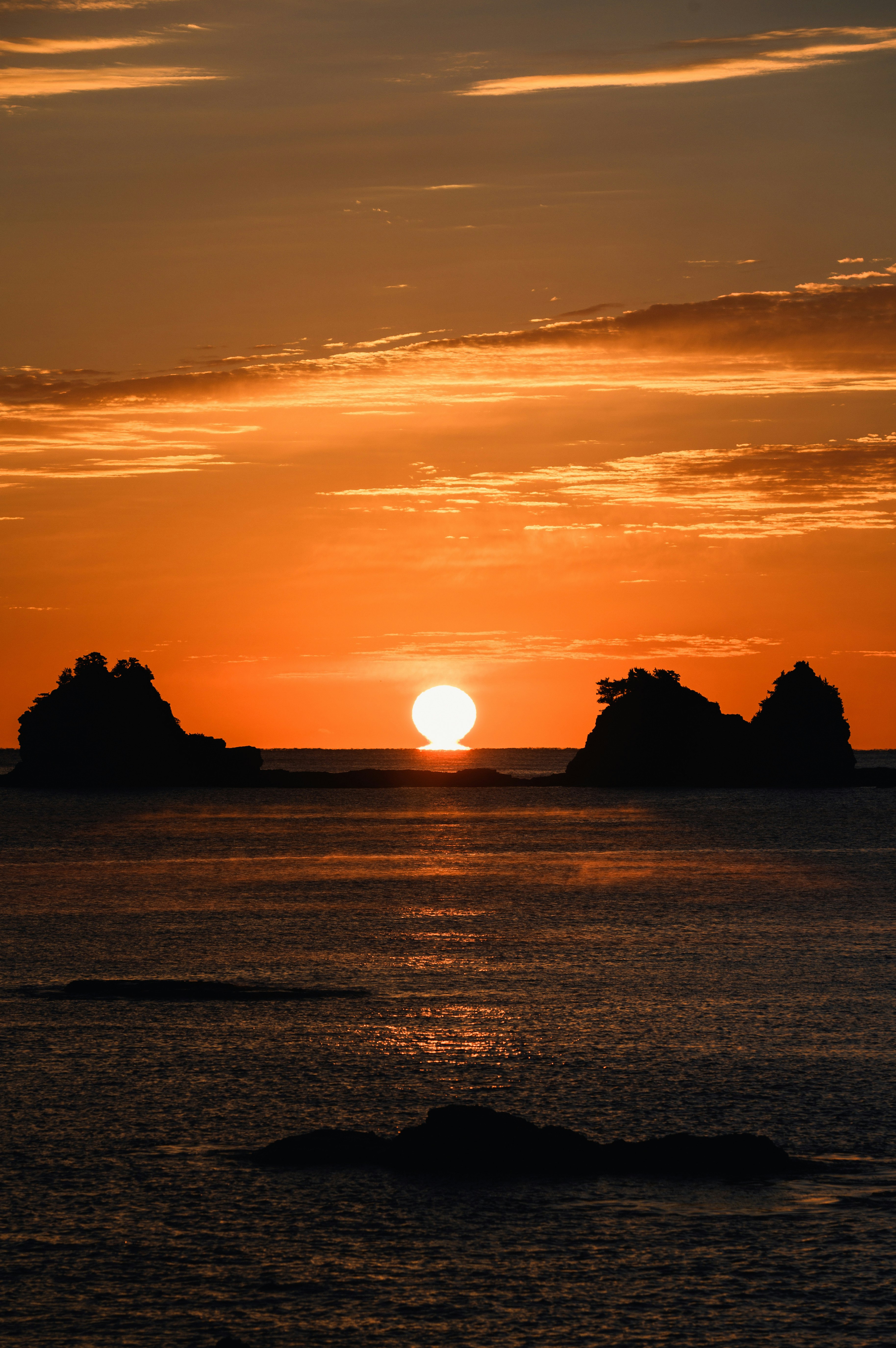夕日に照らされる海と水平線の風景