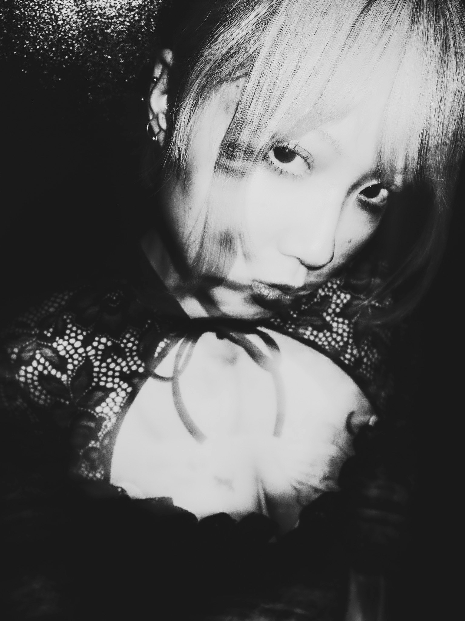 モノクロの肖像写真で、髪の毛が金色の女性がカメラを見つめている