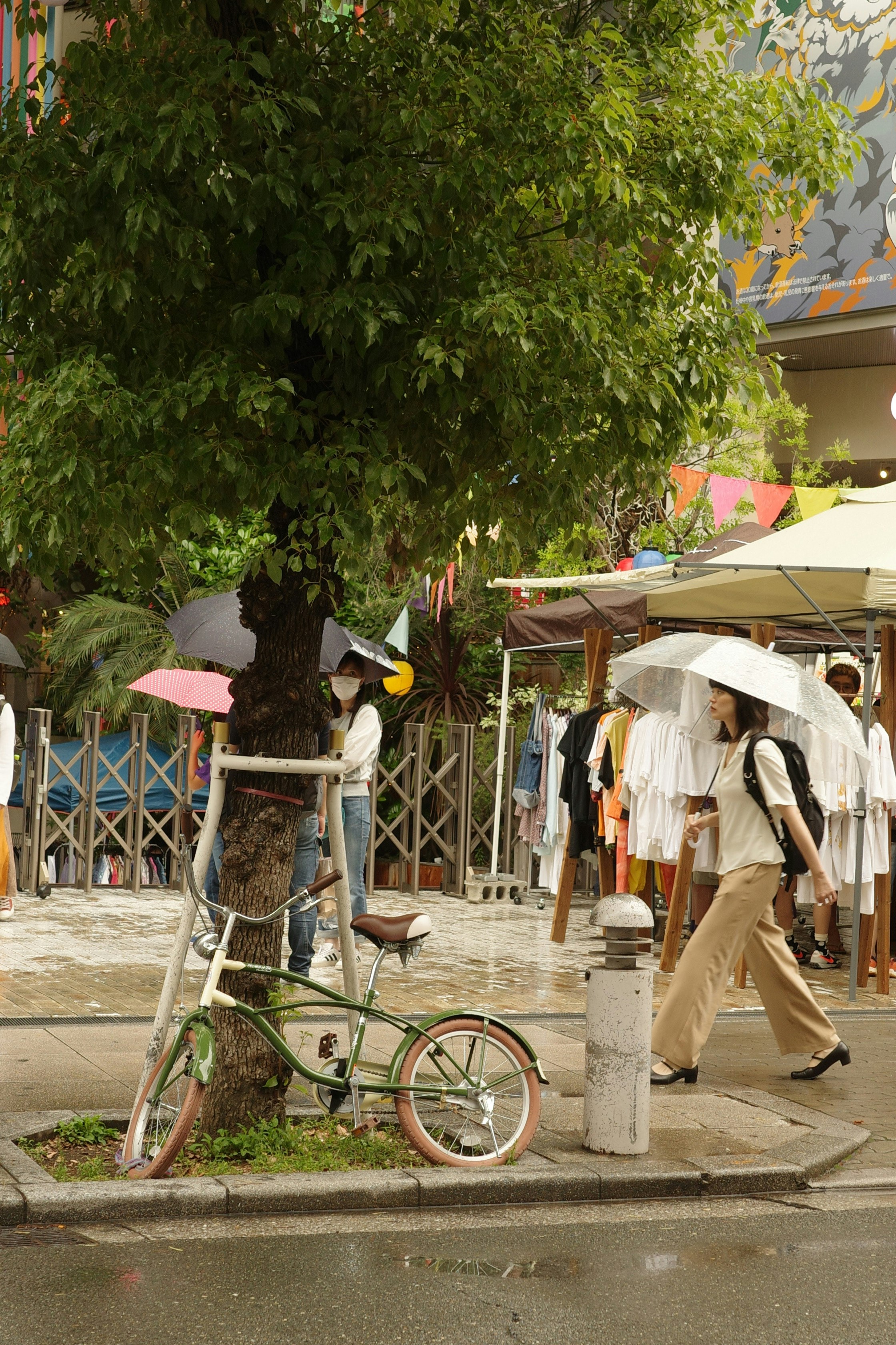 bicycles and umbrellas along a narrow shopping alley storefront