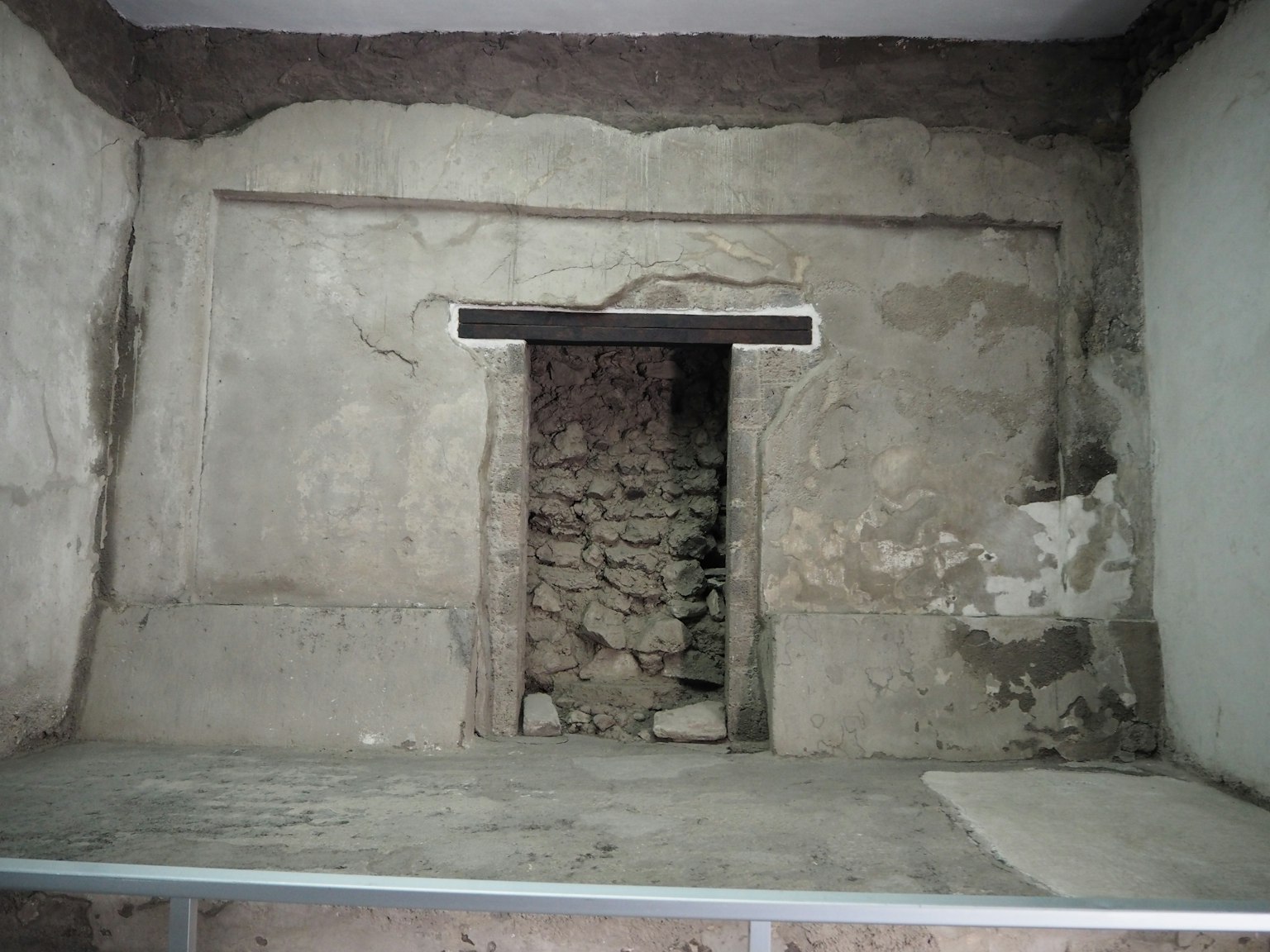 Intérieur d'une chambre ancienne avec une porte en pierre et des murs texturés