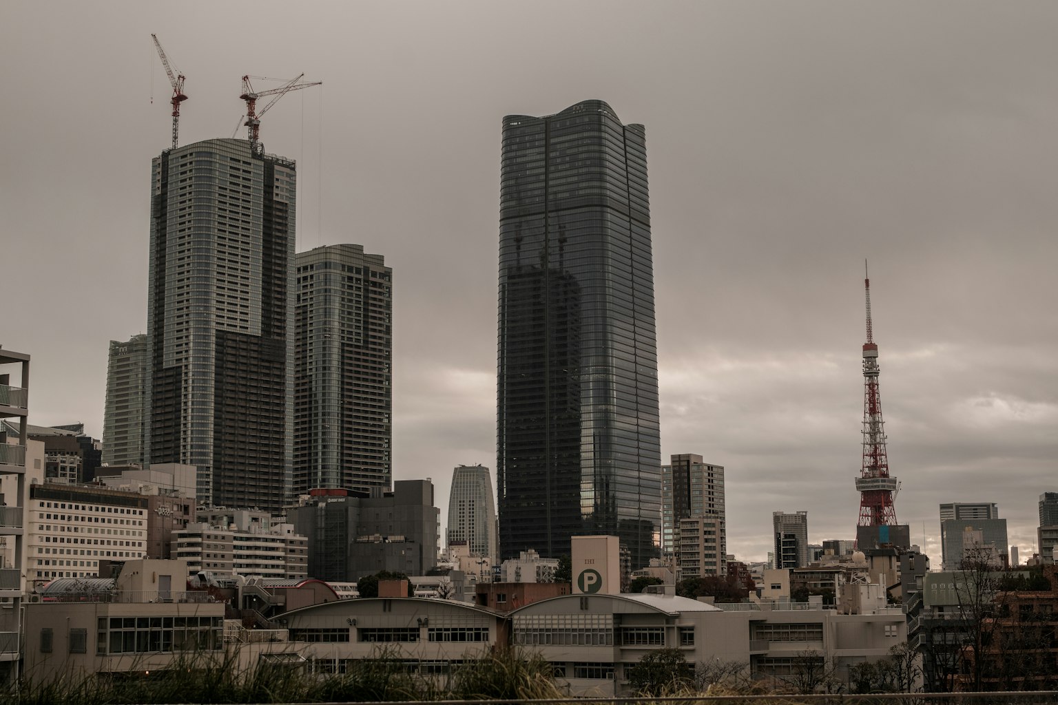Stadtansicht mit Wolkenkratzern und dem Tokyo Tower unter einem bewölkten Himmel